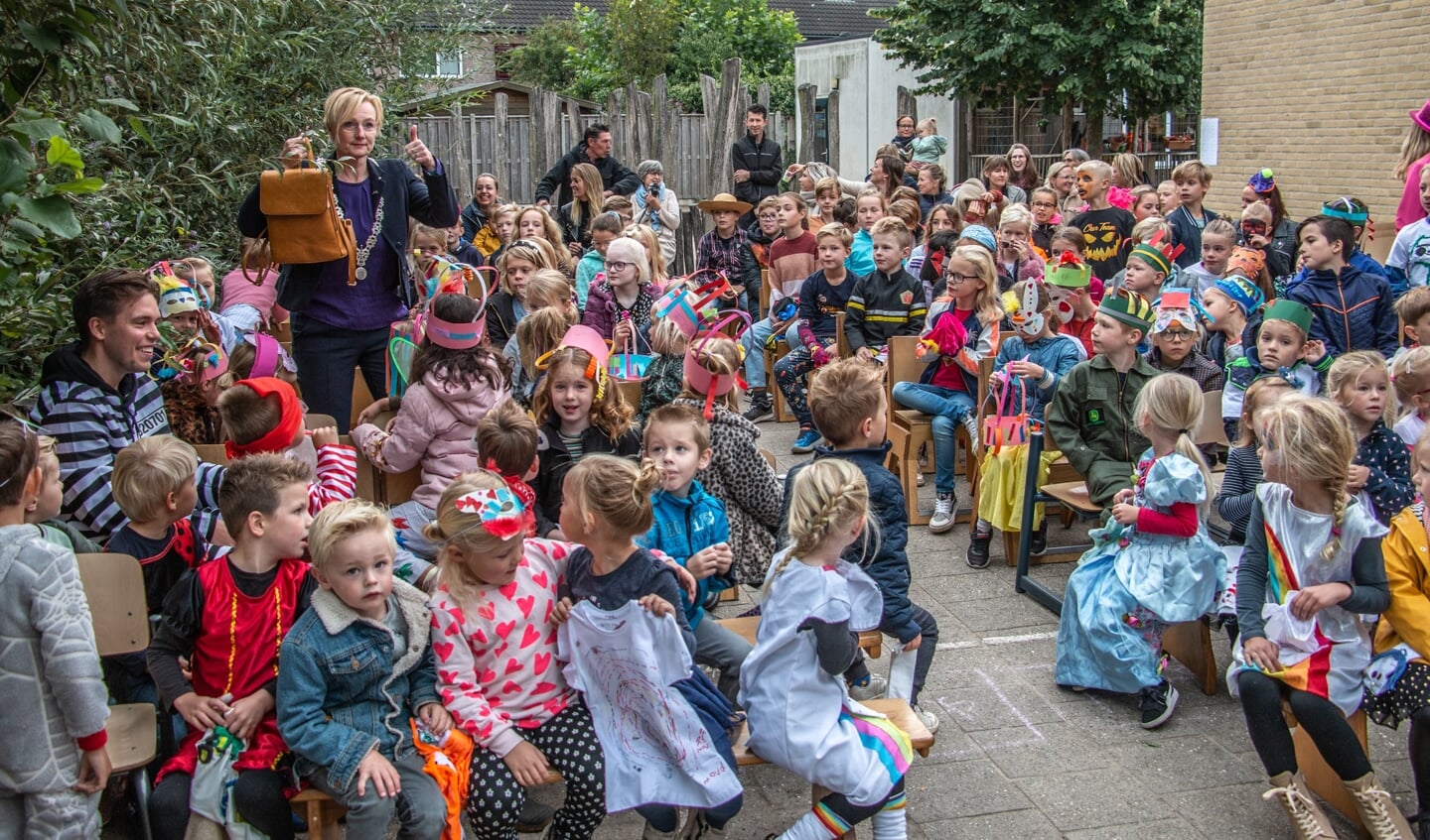 Burgemeester Besselink vindt een plekje bij de kinderen van groep 4 en geniet vervolgens van de mooie optredens. Foto: Liesbeth Spaansen