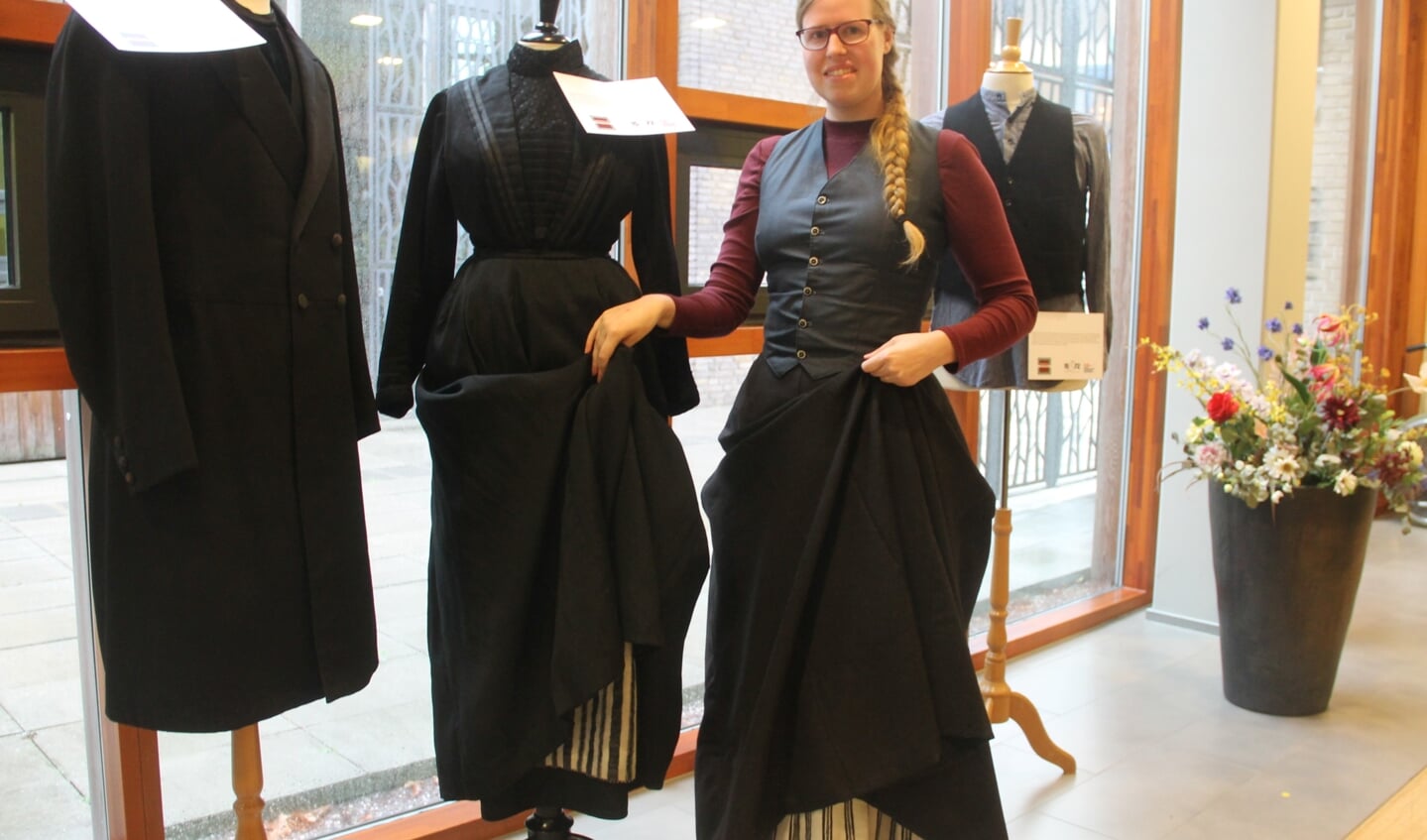 Youandi Heinen in haar nagemaakte kleding naast de originele uit begin vorige eeuw. Foto: Lineke Voltman