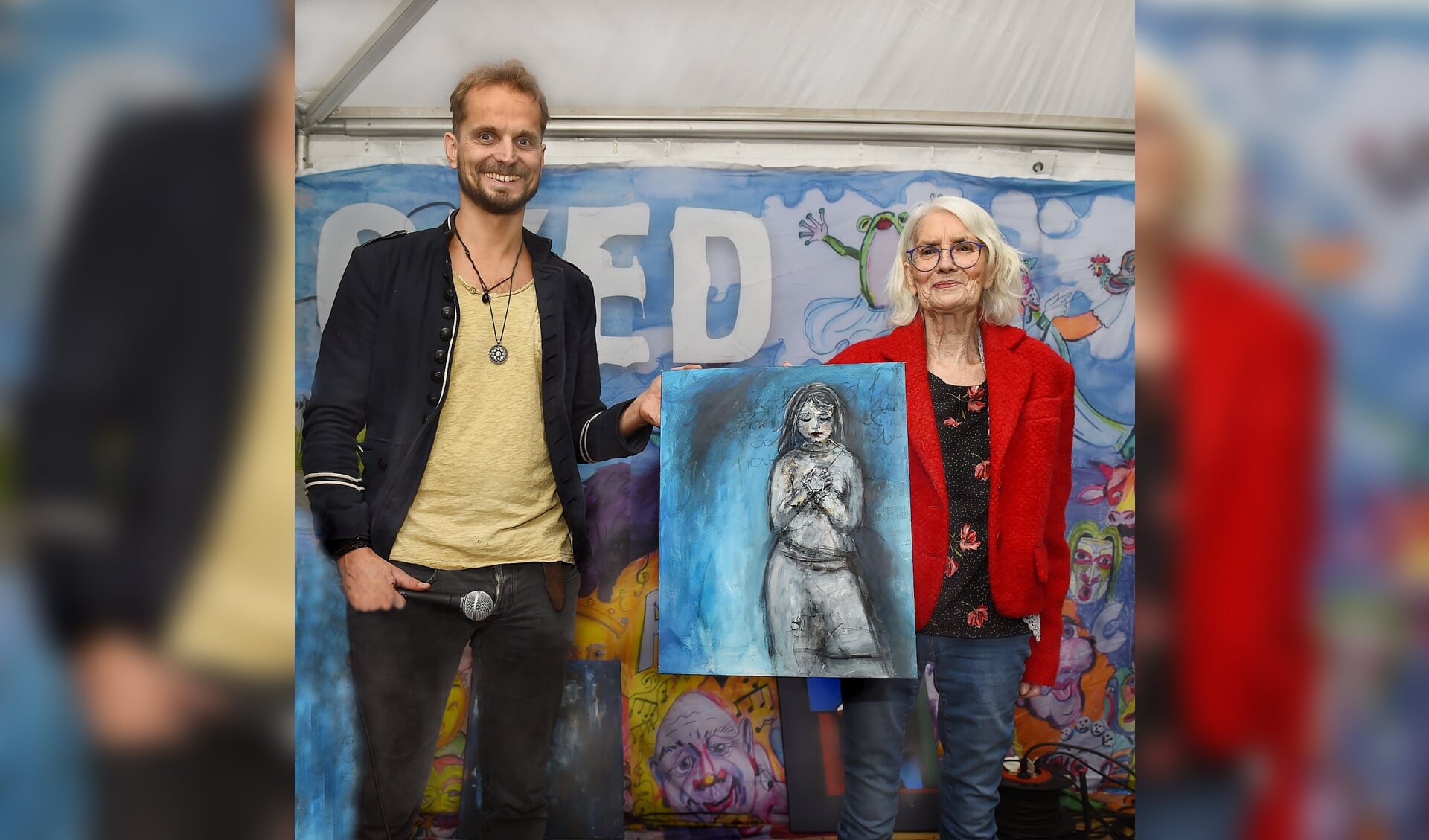 Meindert Bussink overhandigt een schilderij van Ilse van Huet aan Joes Hengefeld, winnaar Lintje van Nieuwe Maan