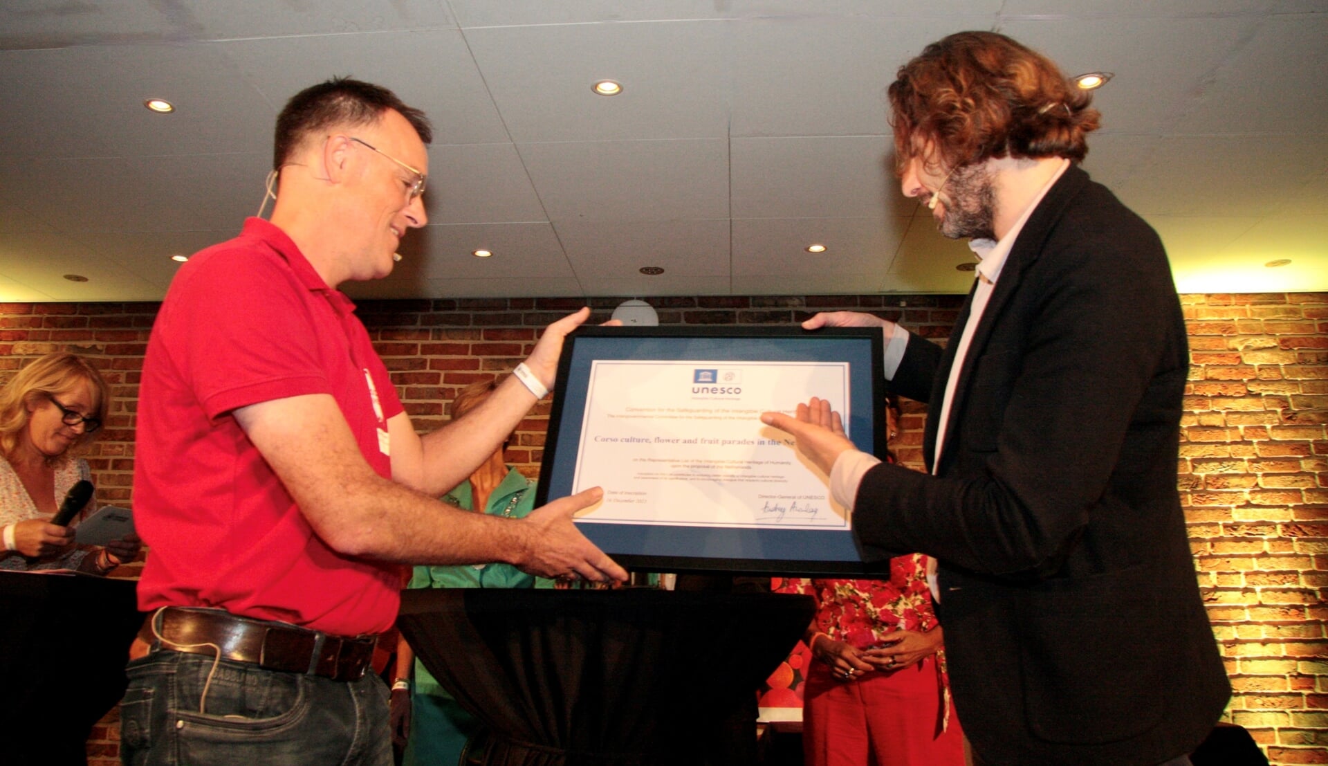 Marco van Baalen, directeur KIEN reikt het officiële UNESCO Certificaat uit aan Paul Bastiaansen (Corsokoepel) in aanwezigheid van de burgemeester Annette Bronsvoort en Herman ter Haar (SBL). Foto: Eveline Zuurbier