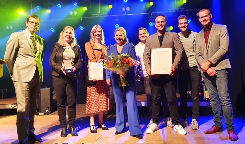 Burgemeester van Oostrum, naast het bestuur van Muziekvereniging Concordia Beltrum, met de Erepenning en bijbehorende oorkondes. In het midden (met bloemen) een trotse voorzitter Chantal te Braake.