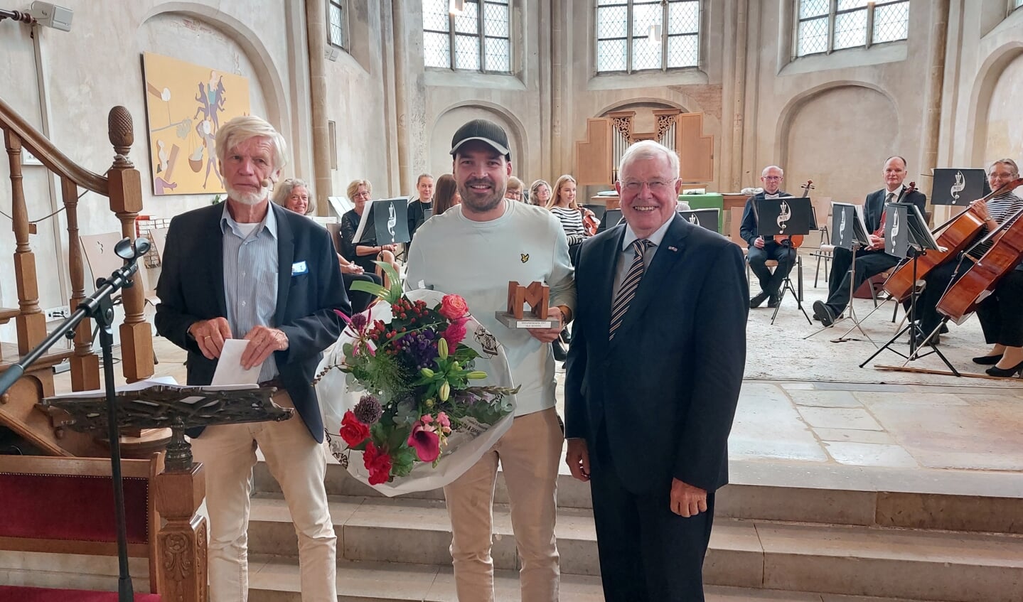 Van links naar rechts: Jurylid Wim Lobeek, winnaar Jeroen Schreurs met de bloemen en trofee en voorzitter van Monumentenbelangen Winterswijk Hans Donderwinkel. Foto Han van de Laar.