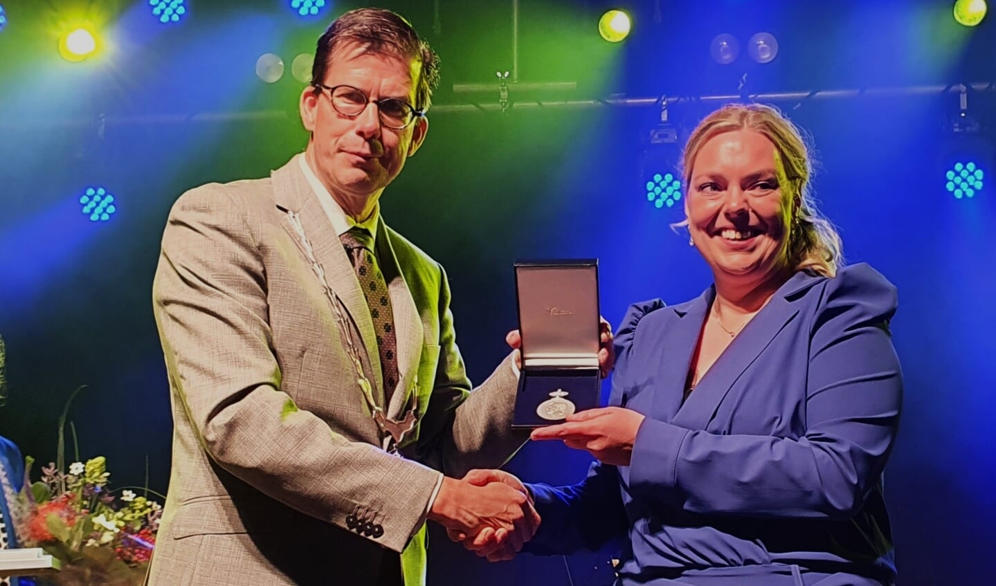 Burgemeester van Oostrum overhandigt de Koninklijke Erepenning aan een trotse voorzitter Chantal te Braake. Foto: Henri Walterbos