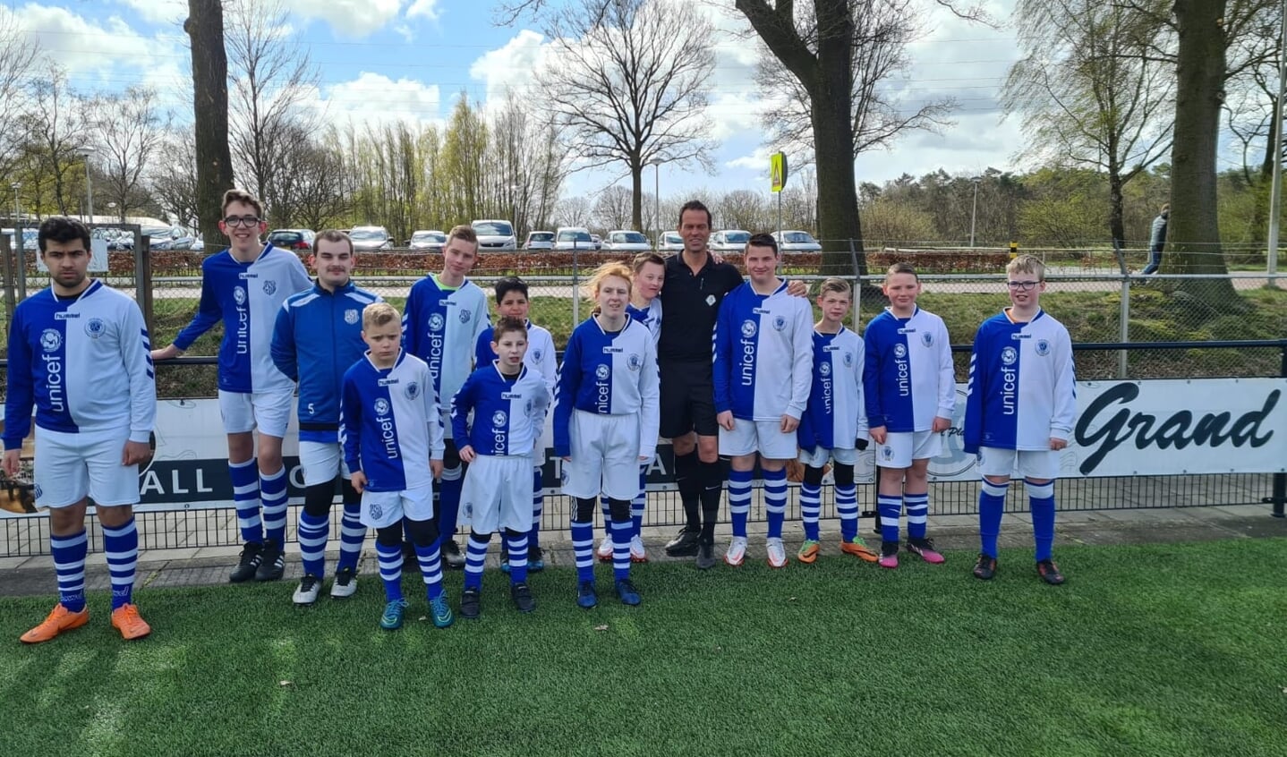 Topscheidsrechter Bas Nijhuis te midden van trotse G-voetballers bij AZC. Foto: PR AZC