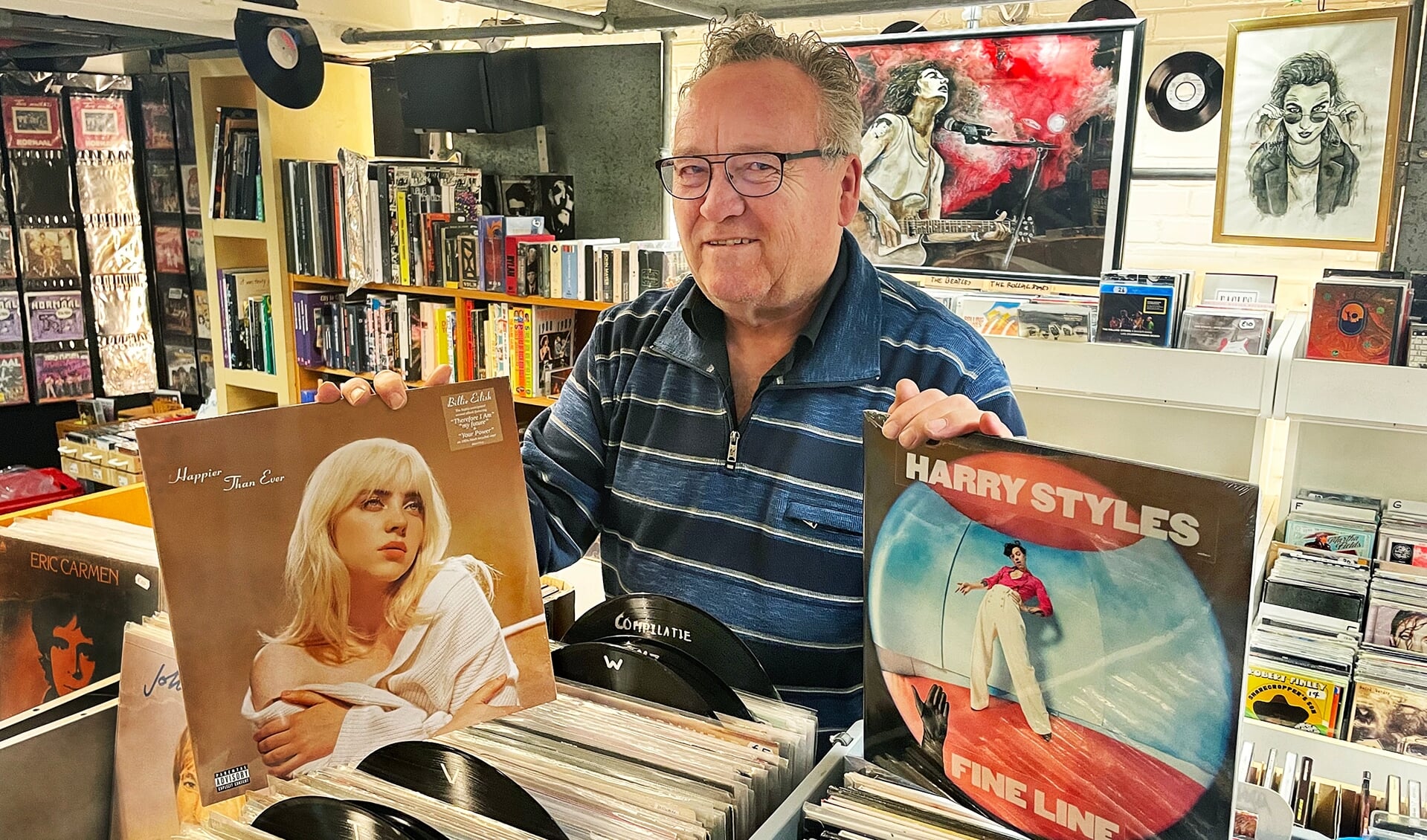 Wim Vriezen in zijn Doetinchemse Muziekkelder met de bij jongeren populaire LP's van Billy Eilish en Harry Styles (foto Roel Kleinpenning)