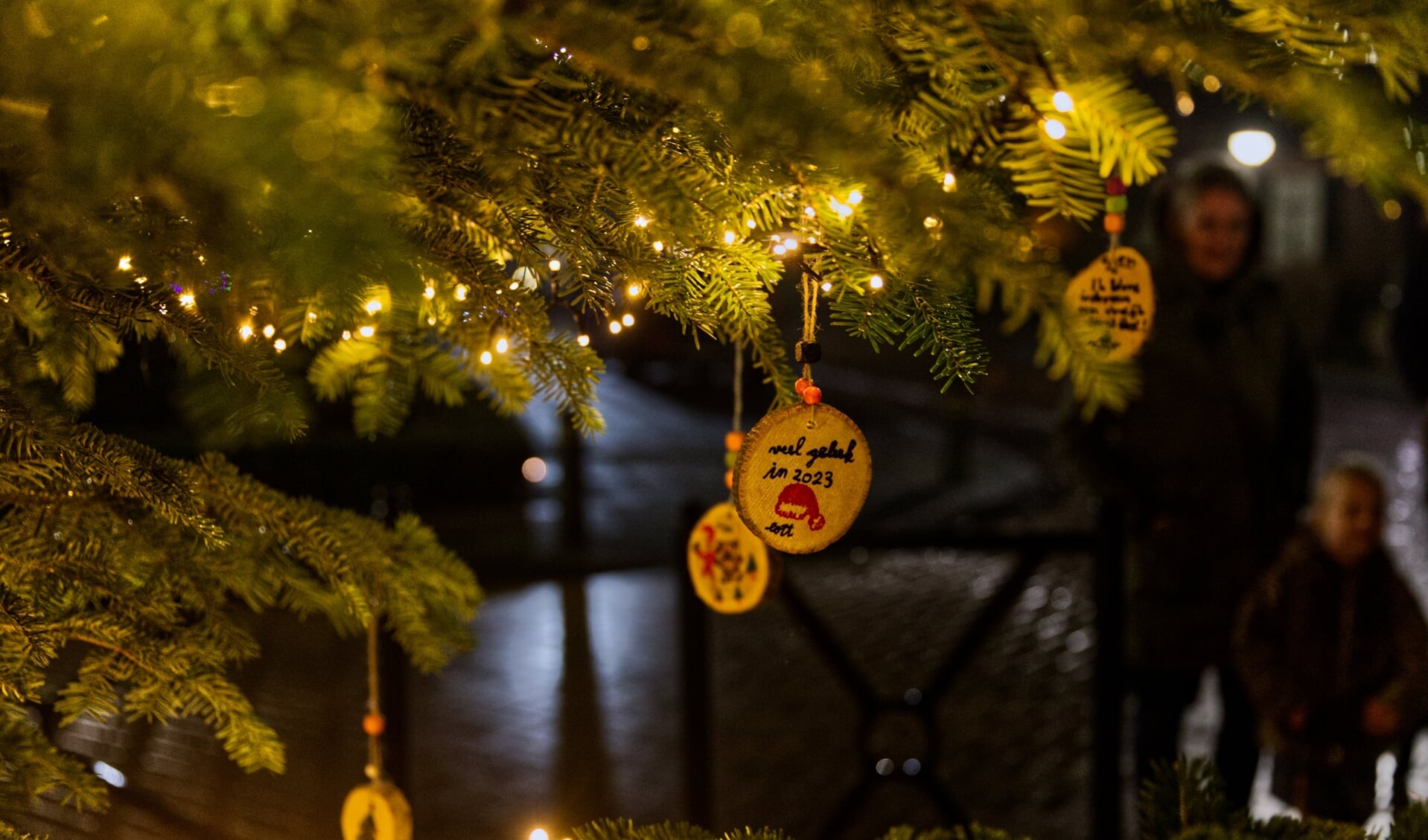 Kinderen mochten kerstwensen ophangen in de verlichte kerstbomen langs de wandelroute. Foto: Geert Kerkhoff