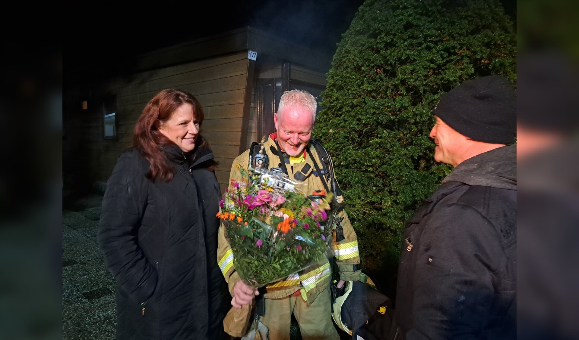 Bloemen voor Manfred Hillen die na 31 jaar stopt bij de vrijwillige brandweer Groenlo. Rechts postcommandant Ivo Reinders, links Anja Hillen. Foto: Kyra Broshuis