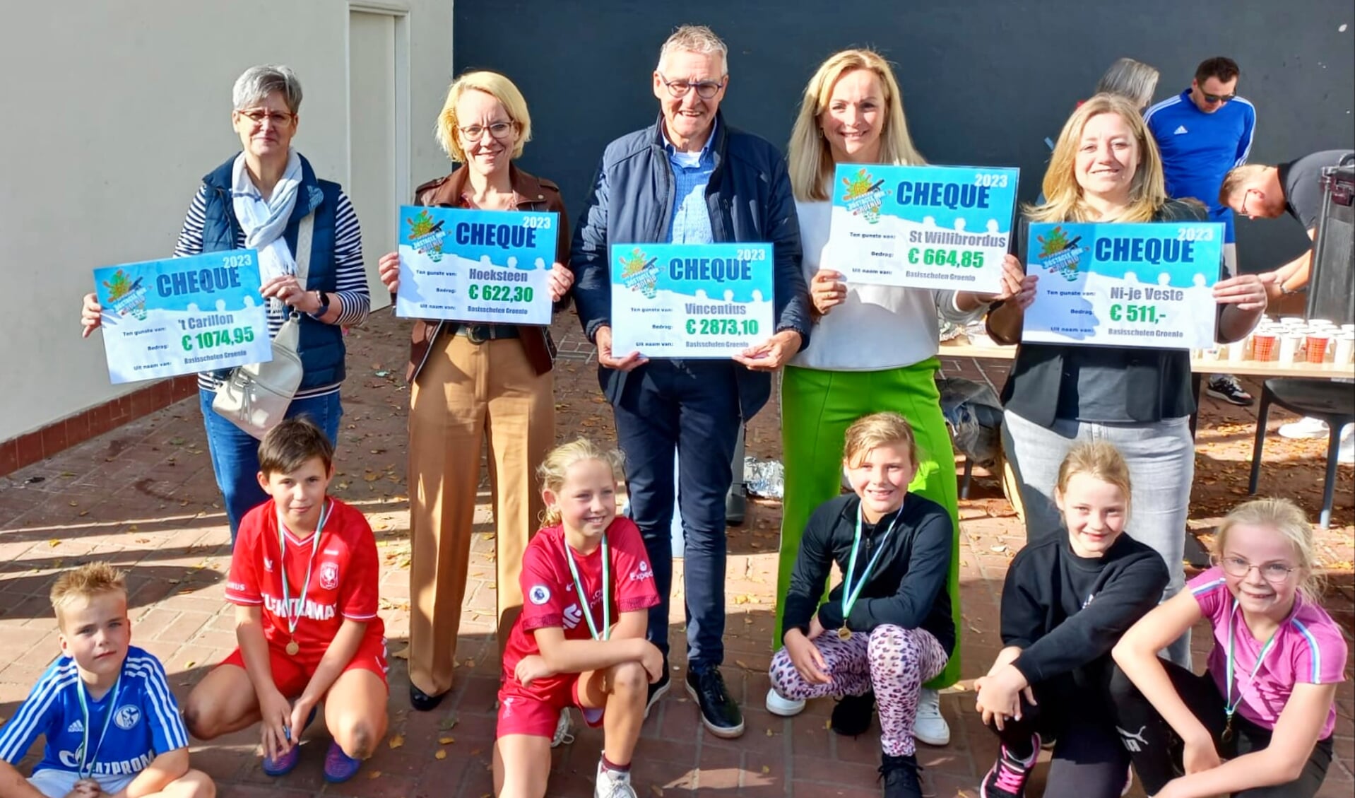 Directeuren en leerlingen van de scholen en Ben Bomers van de Vincentiusvereniging met de cheques. Foto: PR