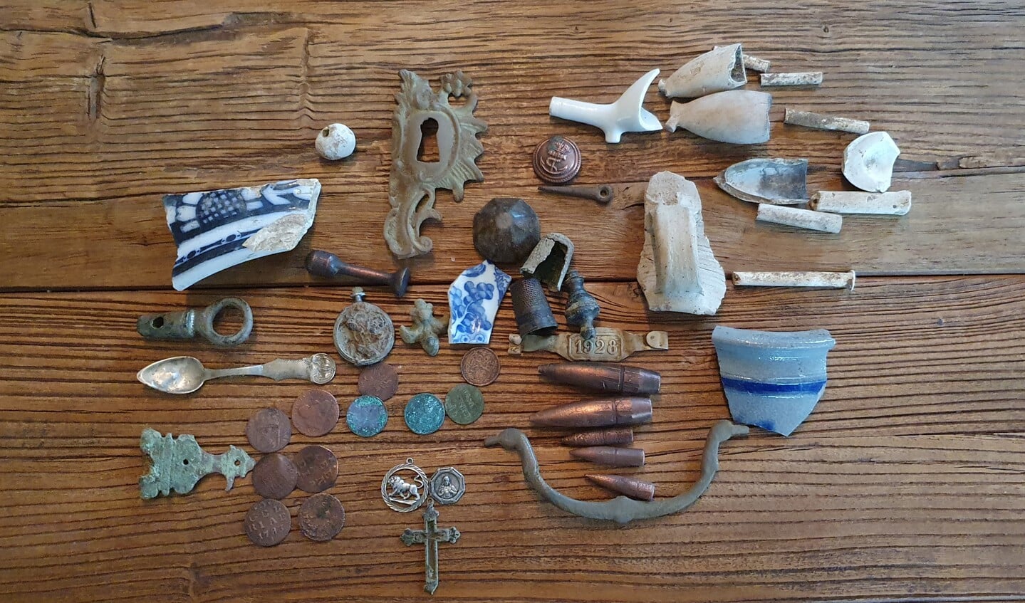 Verschillende voorwerpen, waaronder scherven, hangertjes, munten en kogels die Fred Cramer gevonden heeft met zijn blote oog of met zijn metaaldetector. Foto: Alice Rouwhorst