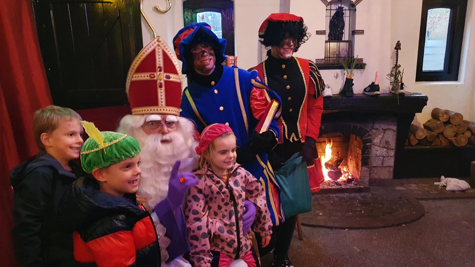 Sinterklaas geniet van het knapperende haardvuur en van blij-glimmende kinderen. Foto: Henri Walterbos