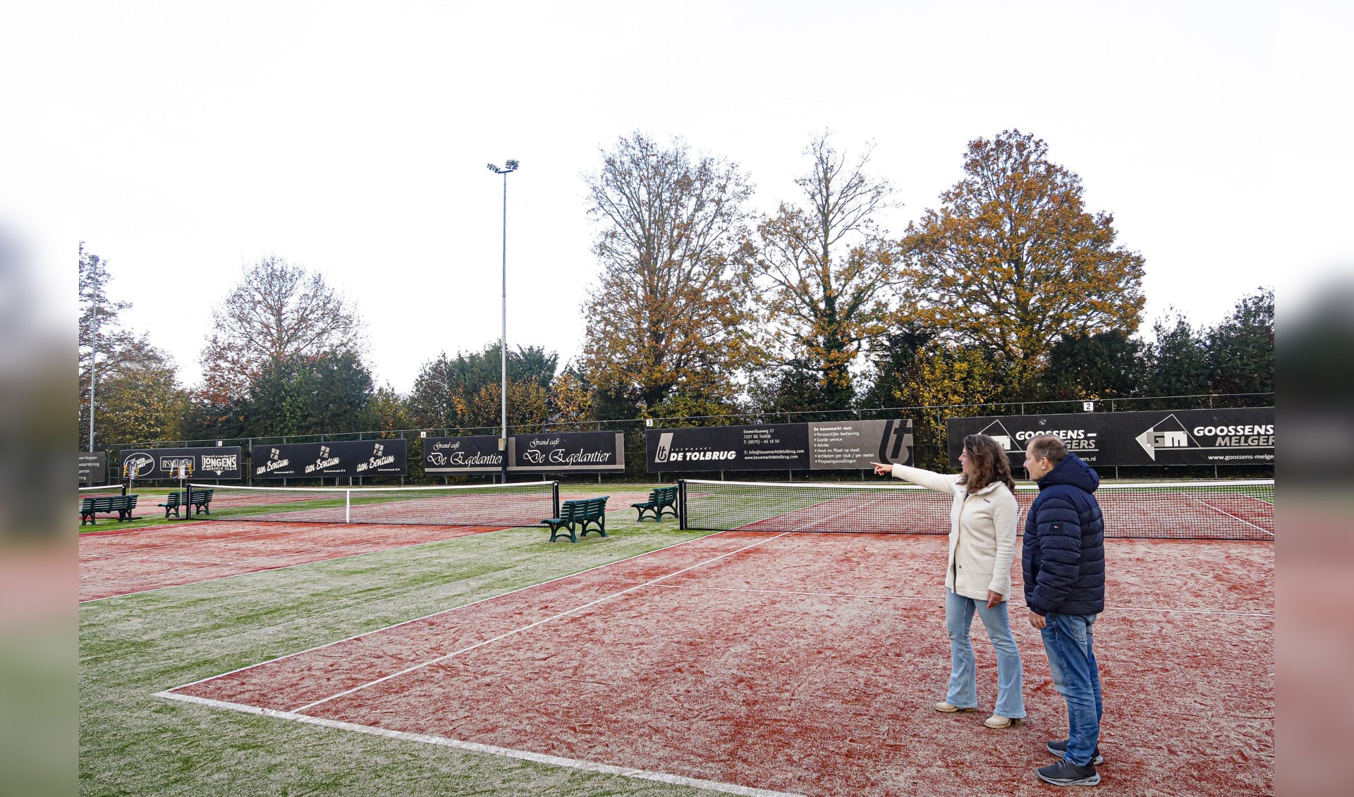 Bestuursleden Michelle Kluiwstra en Derk Jan Menkveld van de Hengelose tennisclub Het Elderink geven uitleg over de vernieuwingen op het tennispark. Foto: Luuk Stam