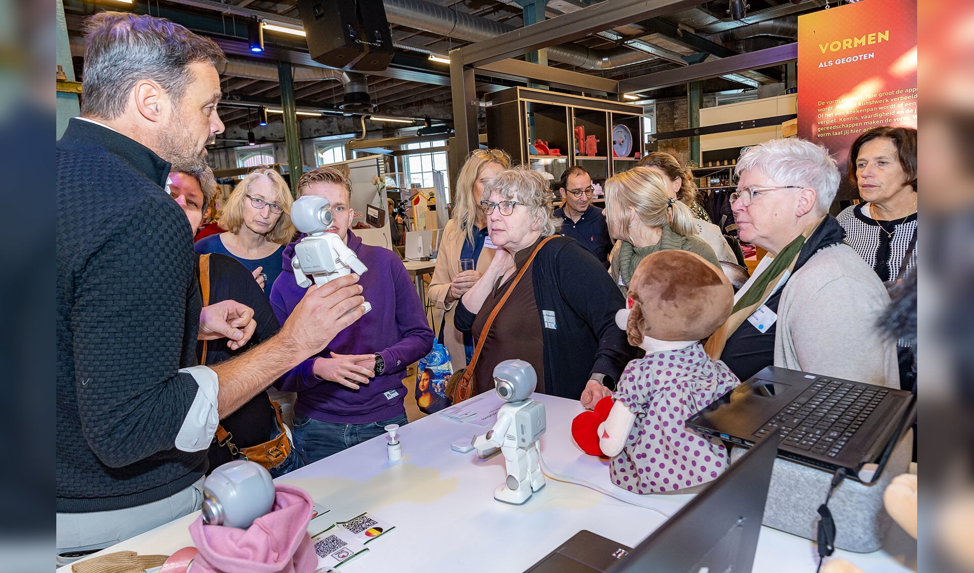 Deelnemers op de innovatiemarkt onder de induk van Maatje, een robot die o.a. kan helpen bij het behouden van dagstructuur. Foto: Henk van Raaij