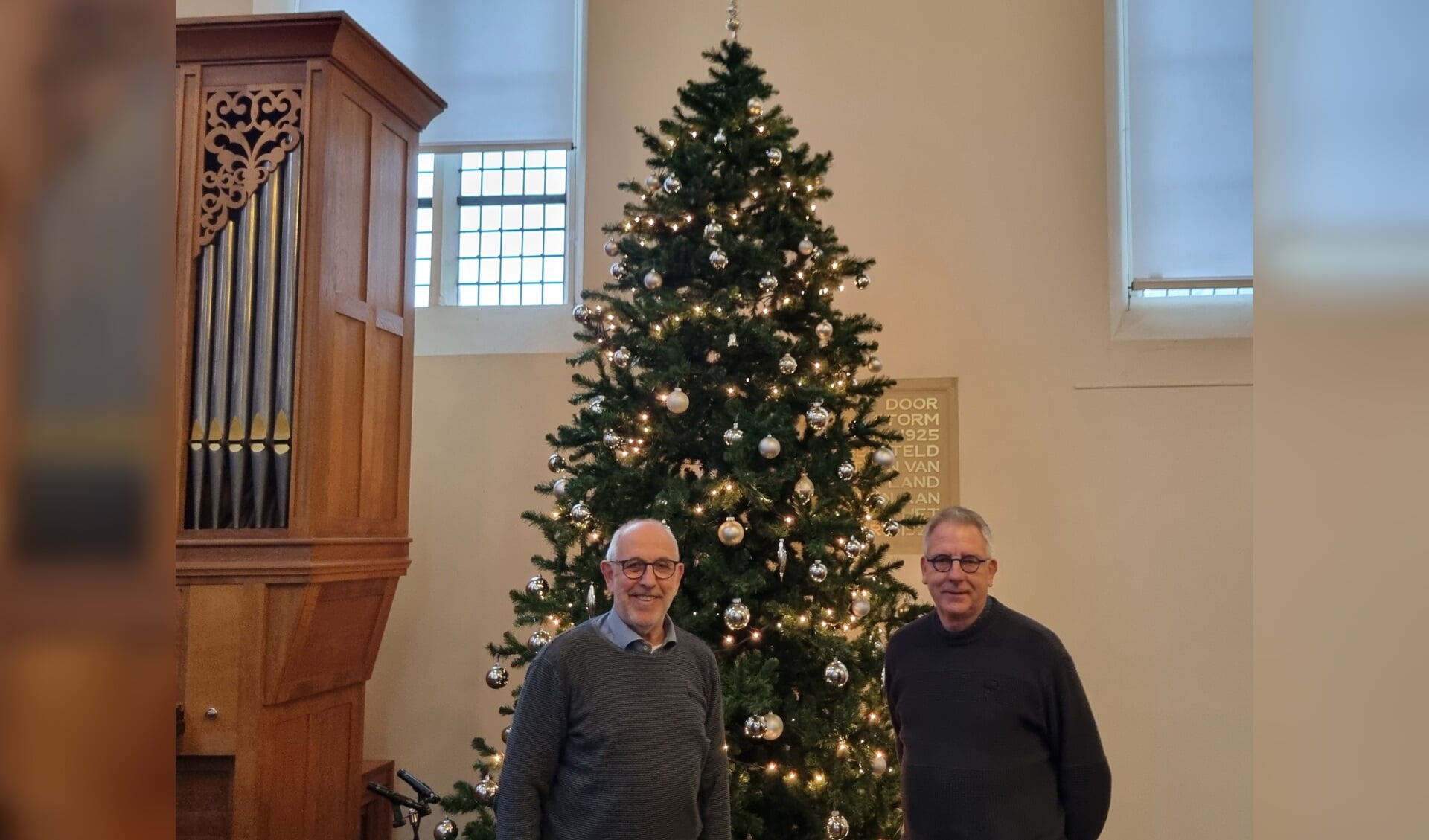 Ds. Co Janssen en voorzitter kerkenraad PG De Wijngaard Bertus Hesselink voor de kerstboom in de Joriskerk. Foto: Rob Weeber