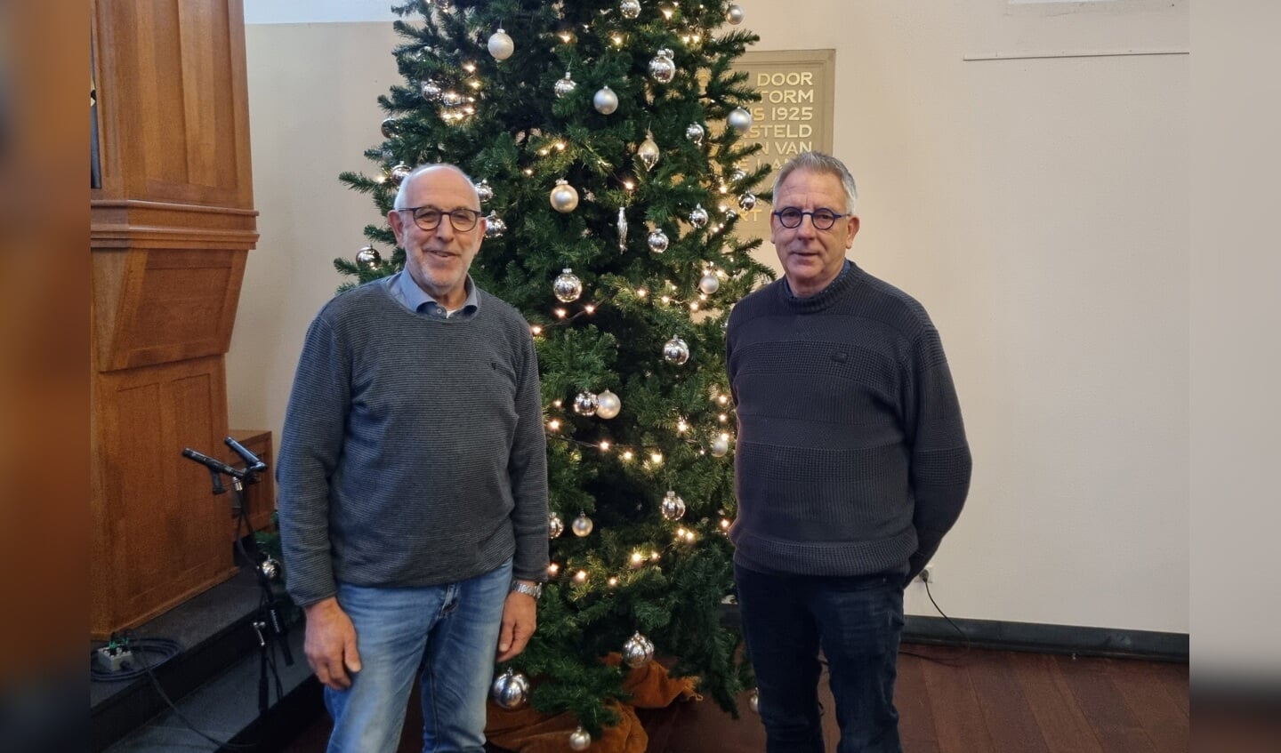 Ds. Co Janssen en voorzitter kerkenraad PG De Wijngaard Bertus Hesselink voor de kerstboom in de Joriskerk. Foto: Rob Weeber