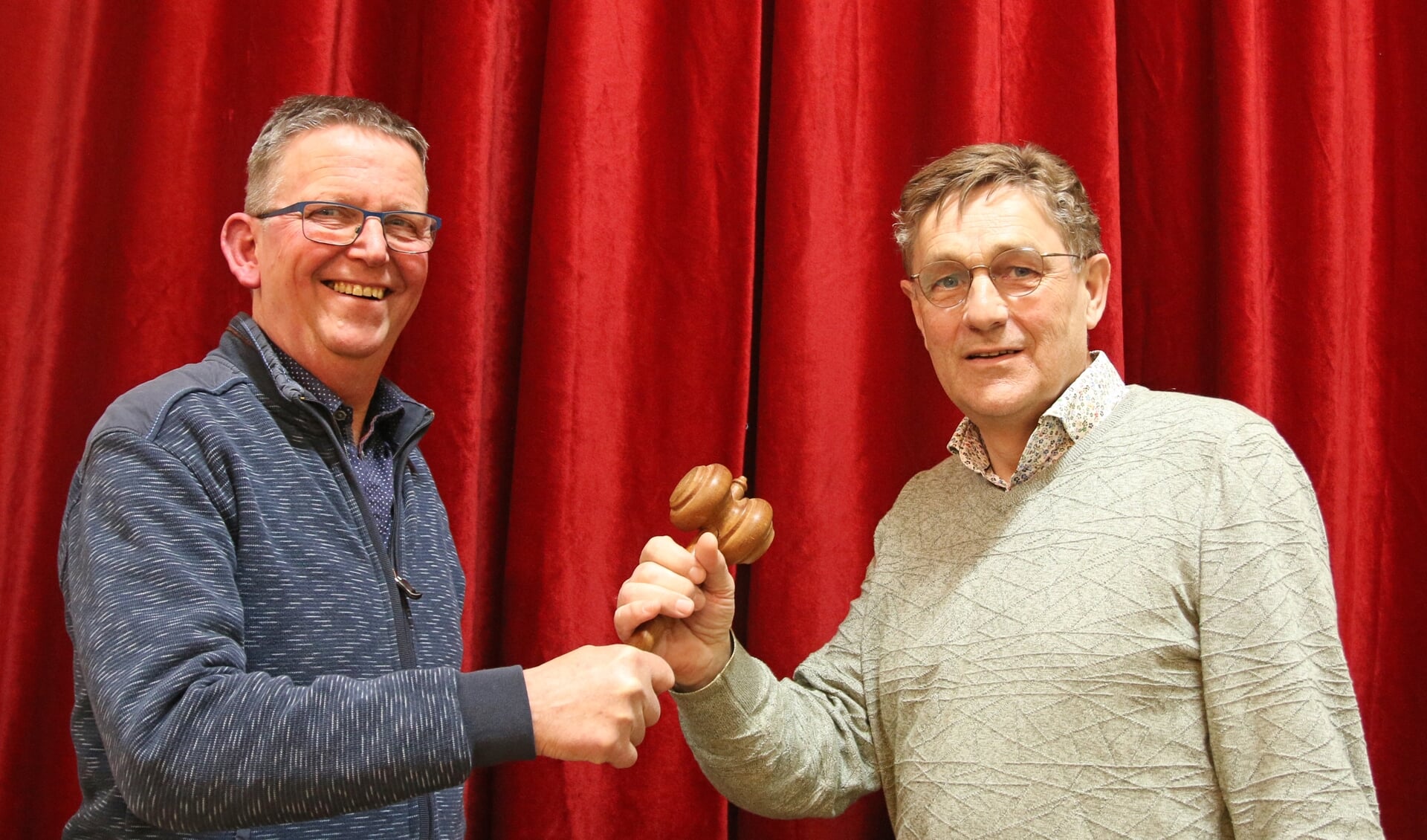De voorzittershamer van het Vorden Mannenkoor wordt door Henk Sleumer overgedragen aan Herman Vrielink. Foto: Theo Frencken