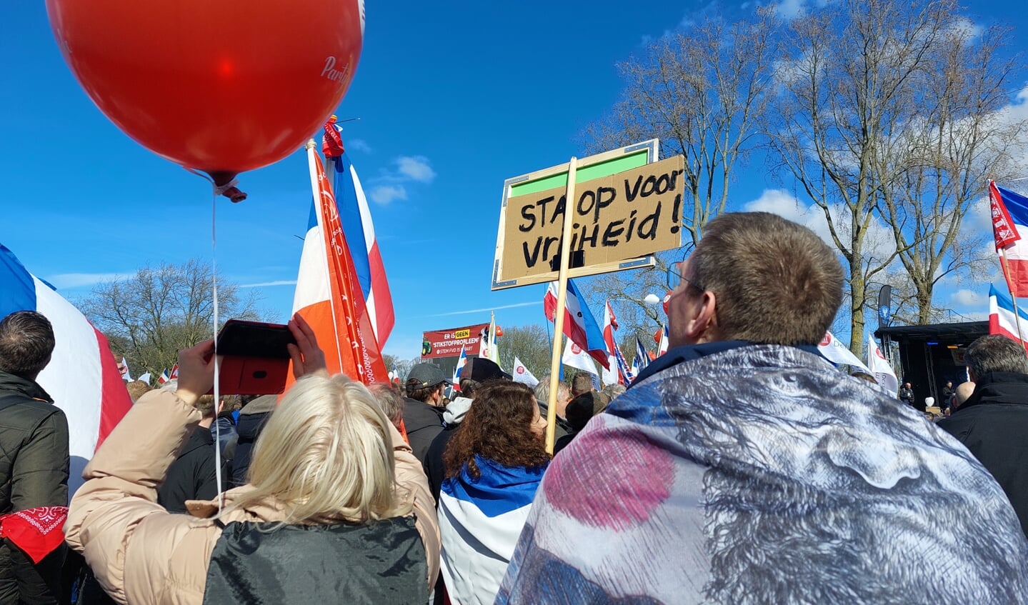 Demonstranten met bord en ballon in Den Haag. Foto: Karin Stronks
