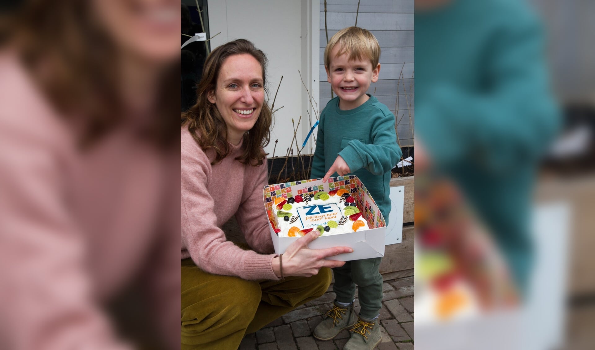 Dieuwke Besselink en haar zoontje met een feestelijke taart, aangeboden door Bakkerij Van Zuijlen. Foto: ZutphenEnergie