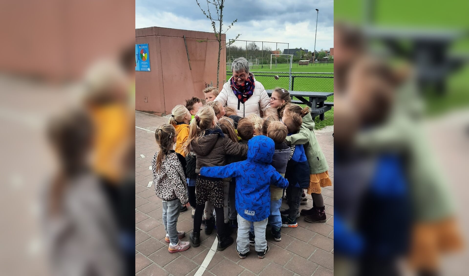 Els Glasbergen krijgt een grote groepsknuffel van de kinderen van groep 1/2. Foto: PR