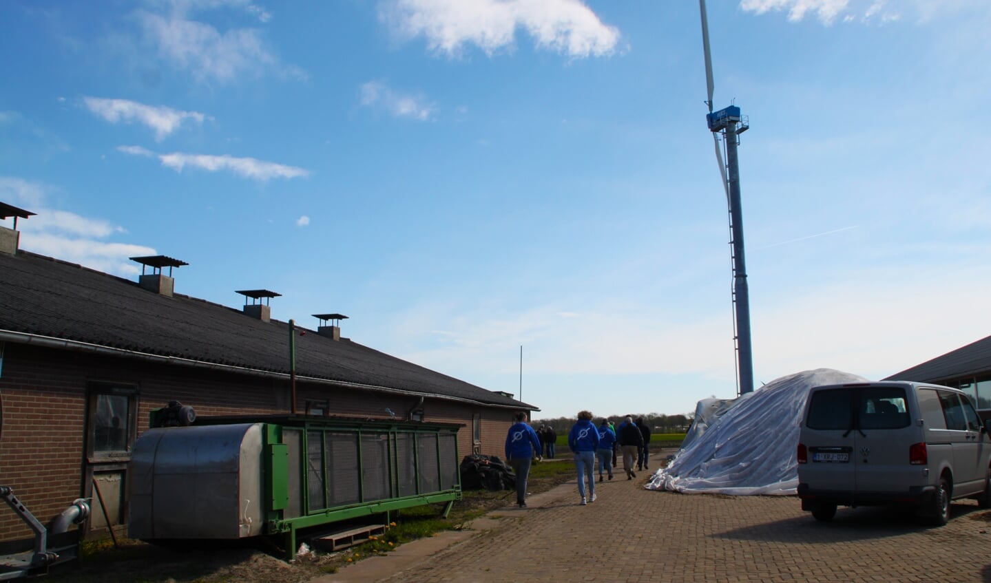 Bezoekers van de informatiedag over windmolens nemen een kijkje bij de windturbine op het erf van kalverboerderij Klein Gunnewiek-Duenk.
