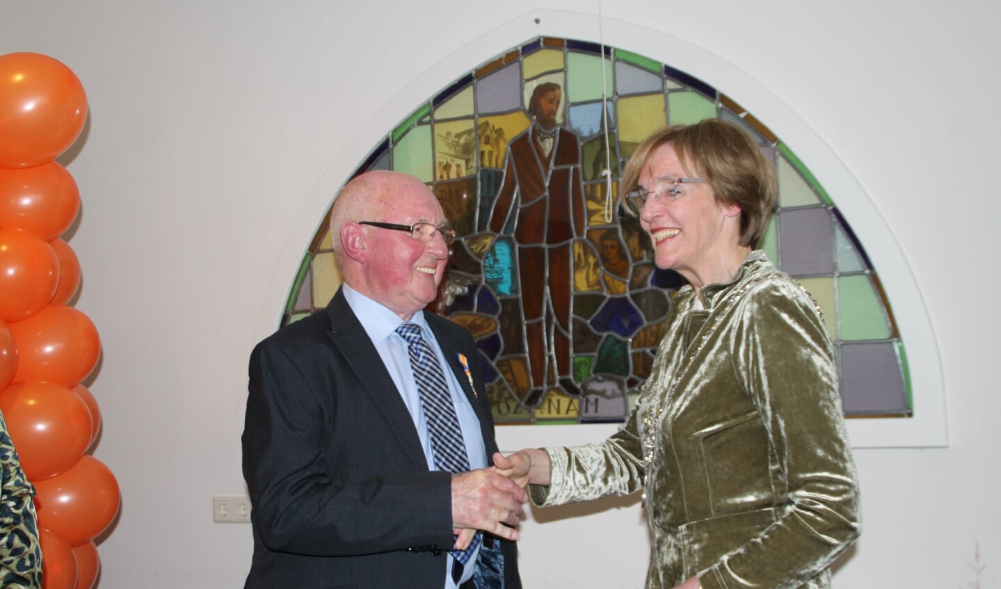 Bennie Schutten wordt gefeliciteerd door burgemeester Bronsvoort.