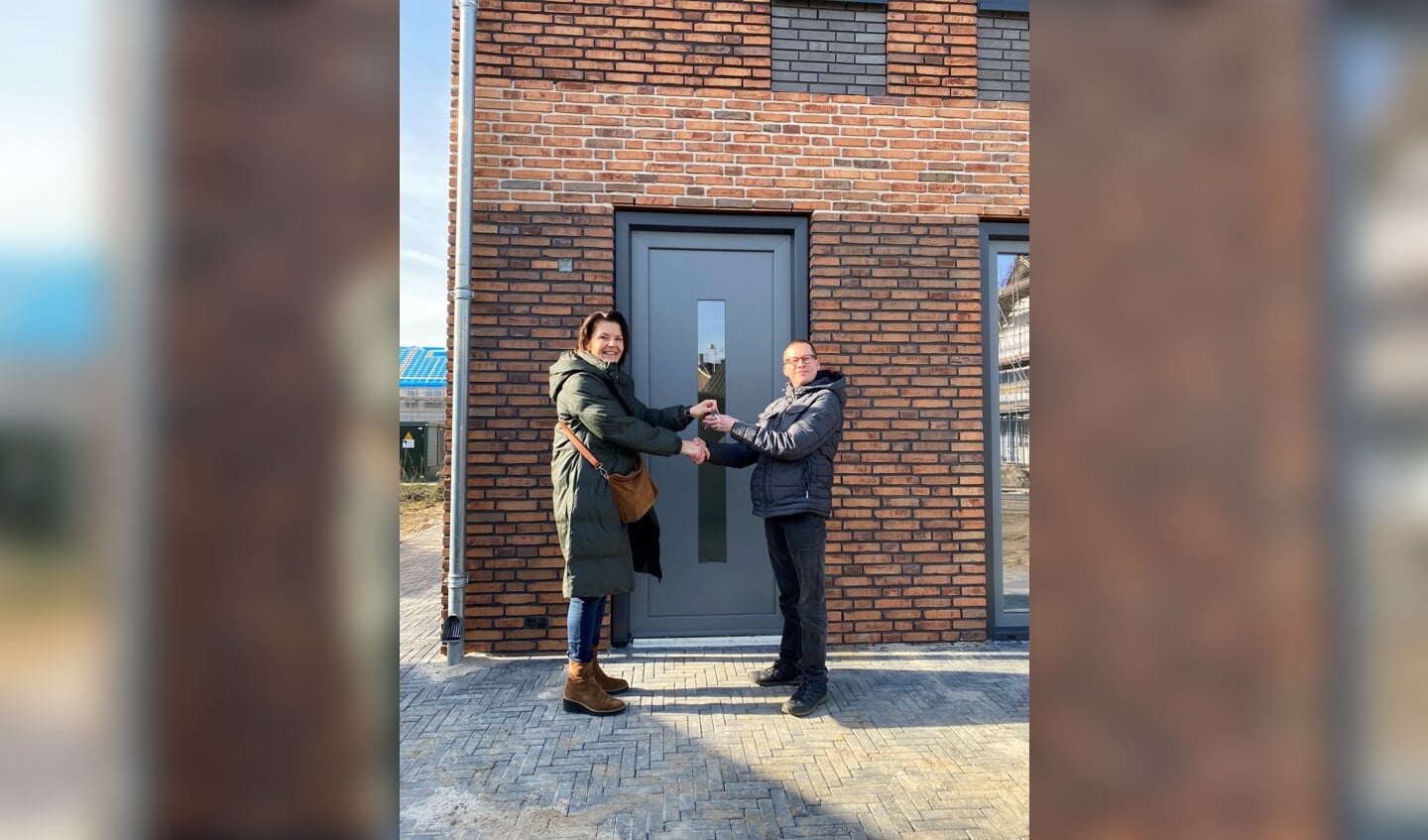 Een medewerker van IJsseldal (l) Wonen verwelkomt een bewoner van een van de 20 sociale huurwoningen in het plan Detmerskazerne in Eefde. Foto: IJsseldal Wonen