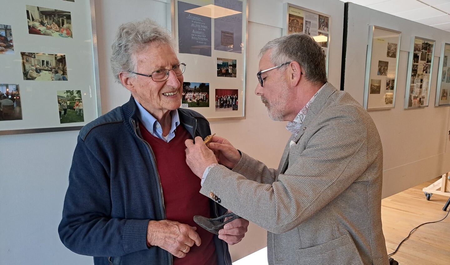 Dr. Johan de Boer krijgt door wethouder Blaauw de versierselen opgespeld die horen bij de onderscheiding Bronzen Haas. Foto: Mirjam Rensink