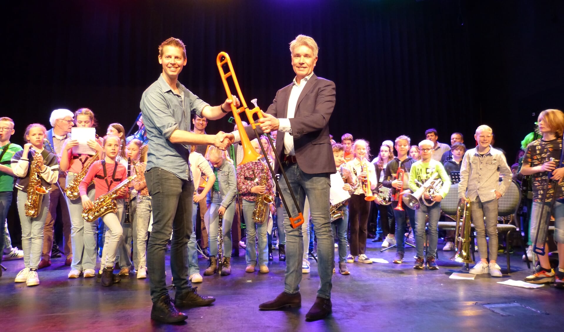 SMOOG-docent Bas Konings (links) ontvangt het eerste geschonken instrument uit handen van Lyons-clublid Koen Knufing. Foto: Lionsclub Groenlo-Slingelanden