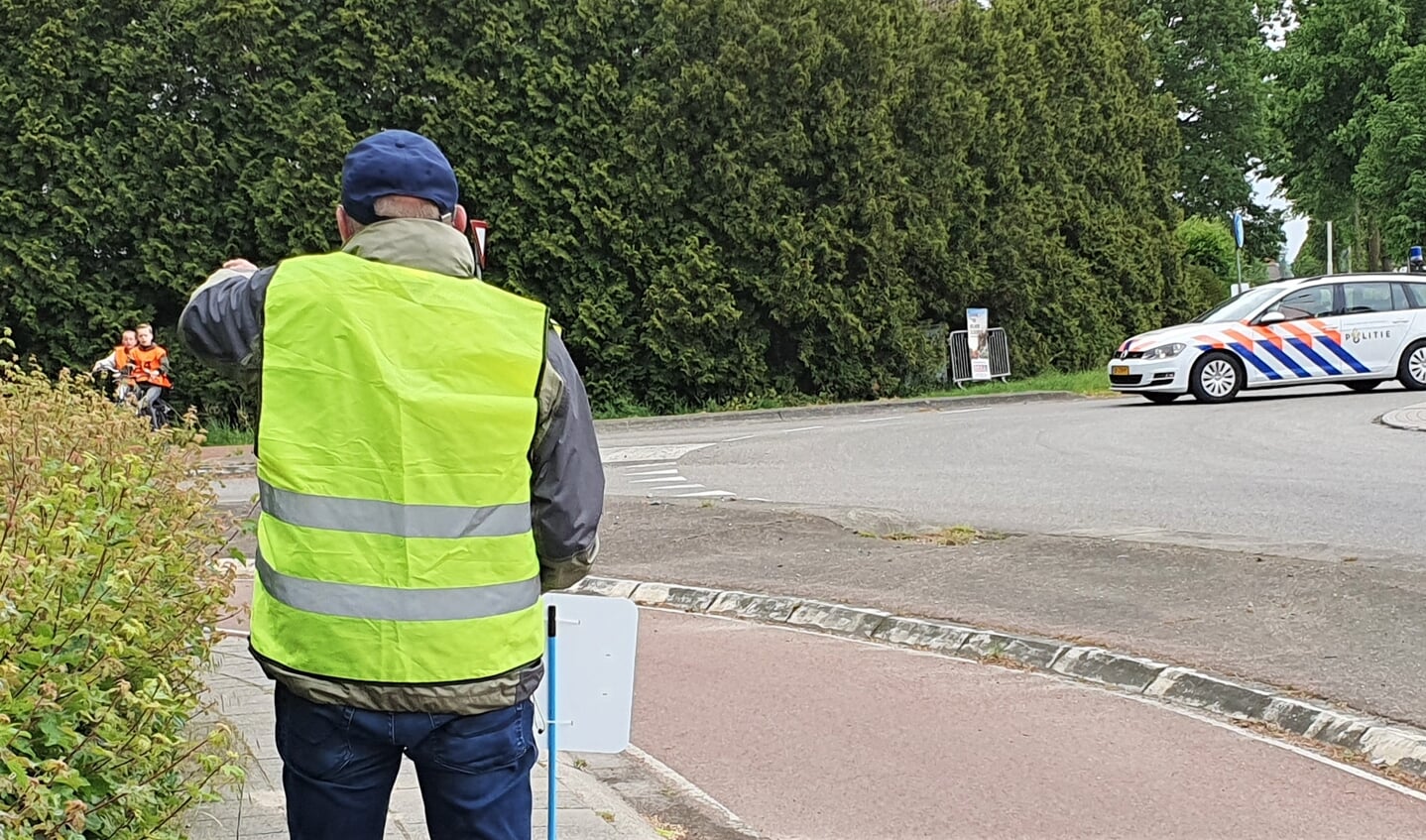 Deelnemers aan het praktisch verkeersexamen krijgen aanwijzingen van een controleur op de route. De politie surveilleert op de route gedurende het examen. Foto: Alice Rouwhorst