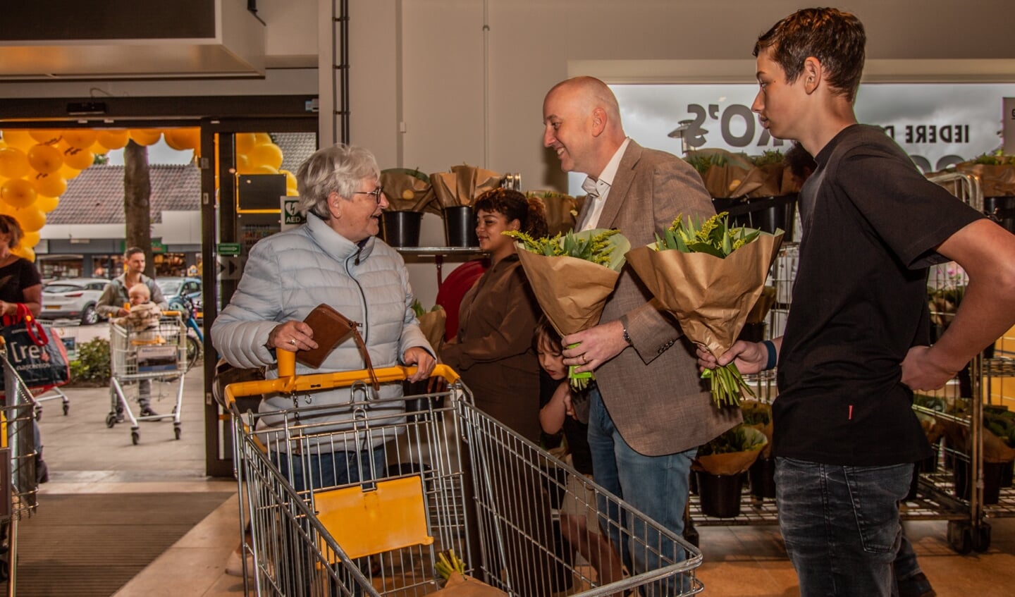 De familie Hollak deelt na de officiële opening bloemen uit aan klanten. Foto: Liesbeth Spaansen