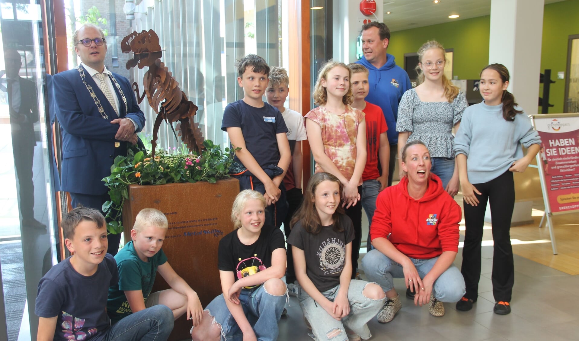 Burgemeester Joris Bengevoord en Roel Jansen samen met de kinderen bij de T-Rex. Foto: Lineke Voltman. 