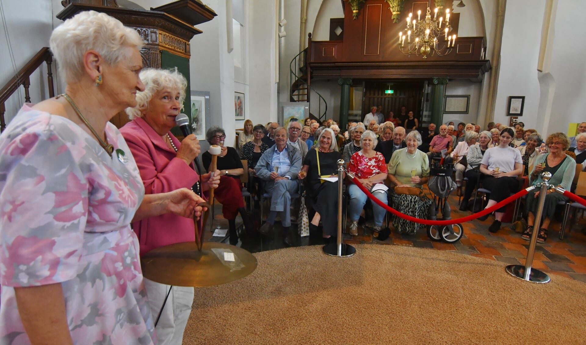 Met een flinke slag op een gong opende voorzitter Barbara Bodegom van KunstKring Ruurlo vrijdagmiddag in de Dorpskerk de expositie ‘KunstKring in de Kerk’. Foto: Kees Avé
