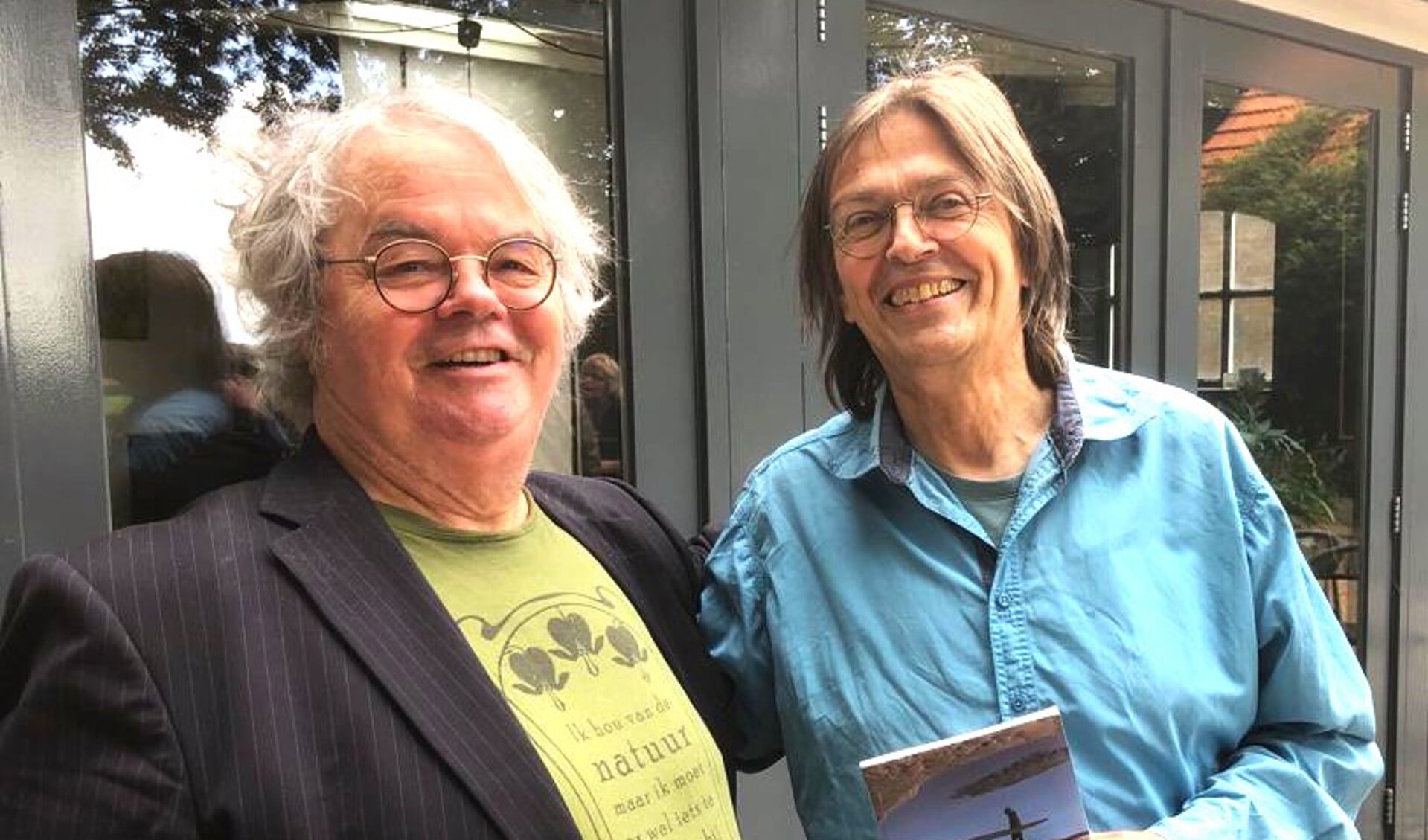Hans Mellendijk draagt het Dichter des Achterhoeks-stokje over aan Sander Grootendorst (rechts). Foto: Gerwin Nijkamp