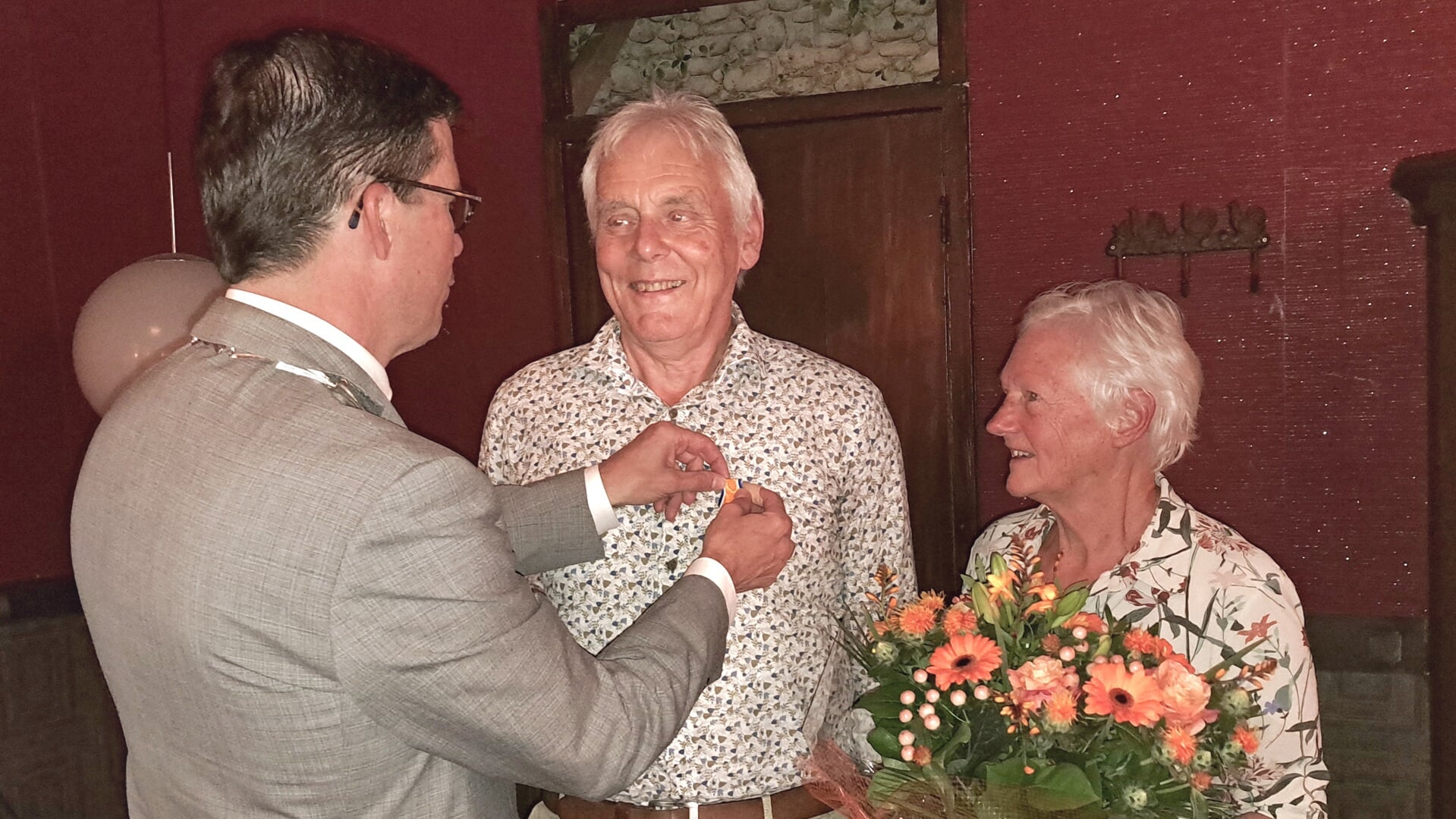 Jan Pape krijgt van burgemeester Joost van Oostrum de versierselen opgespeld die horen bij de Koninklijke Onderscheiding. Foto: Kyra Broshuis 