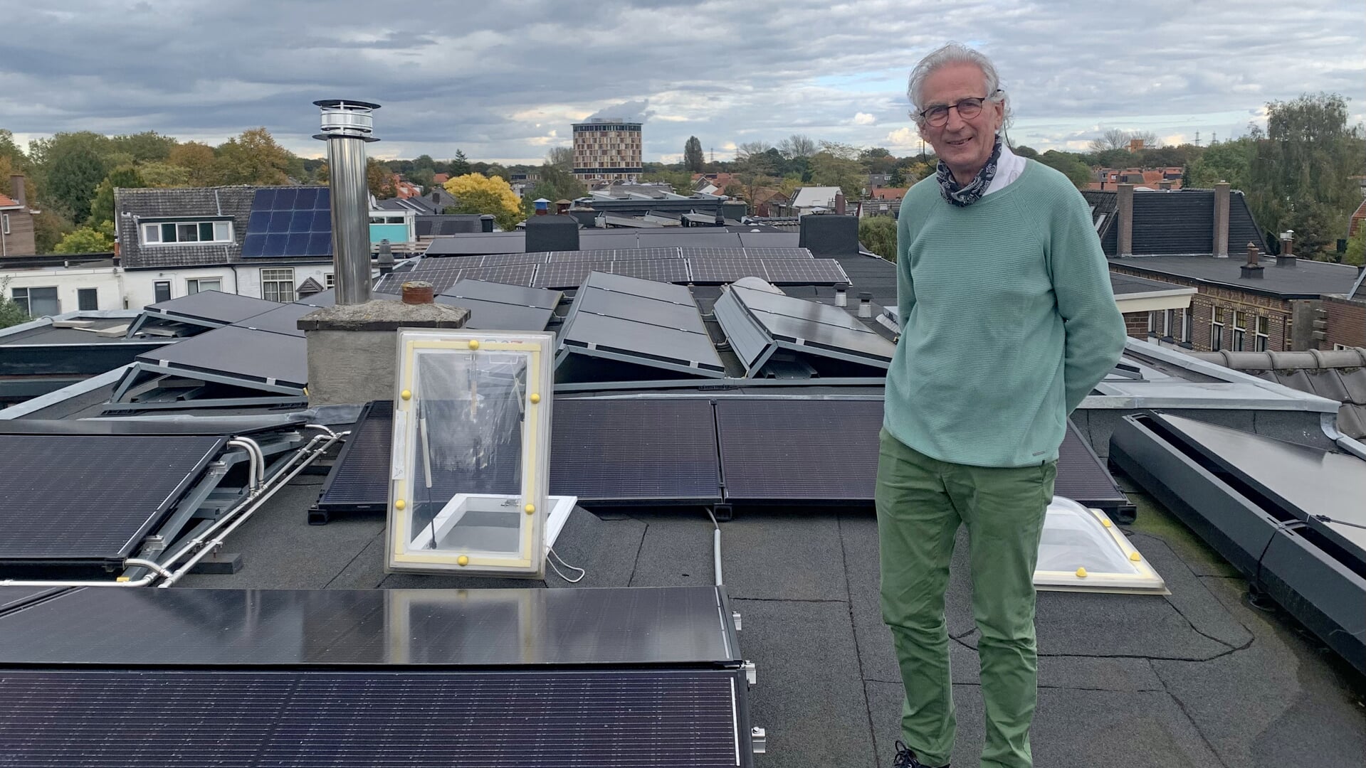 Cees de Boer op het dak van zijn huis aan de Weg naar Laren. Te zien is dat er in Noordveen al heel wat daken van zonnepanelen zijn voorzien. Foto: Sander Grootendorst