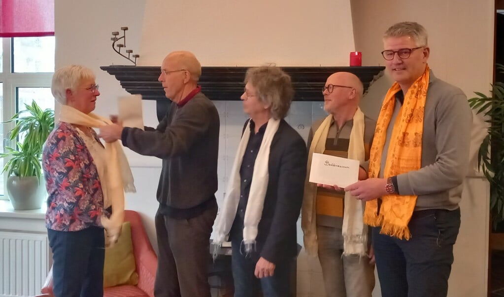 Jan Nikkels overhandigt onder toeziend oog van Fons Rouwhorst, Frans Berendsen en Marc van der Linden een Nepalese sjaal aan Ineke Berendsen. Foto: Ineke Heinen  