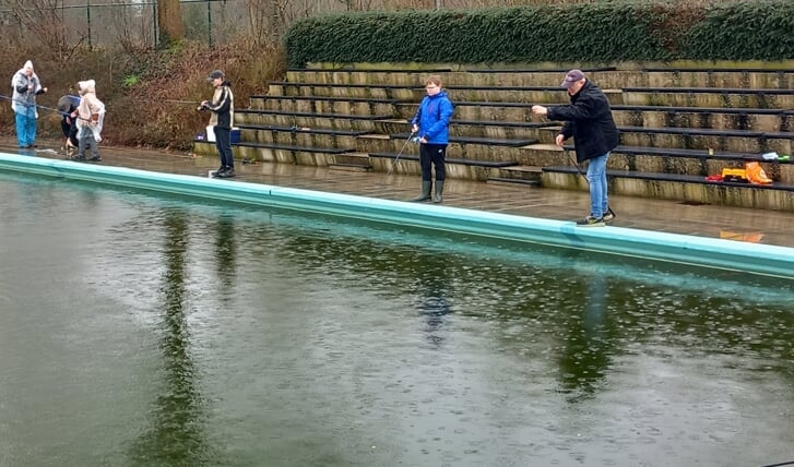 Vader Robert en zoon Steijn Reindsen (r) hengelden samen zes forellen uit het water van het grote bassin van zwembad De Meene. Foto: PR