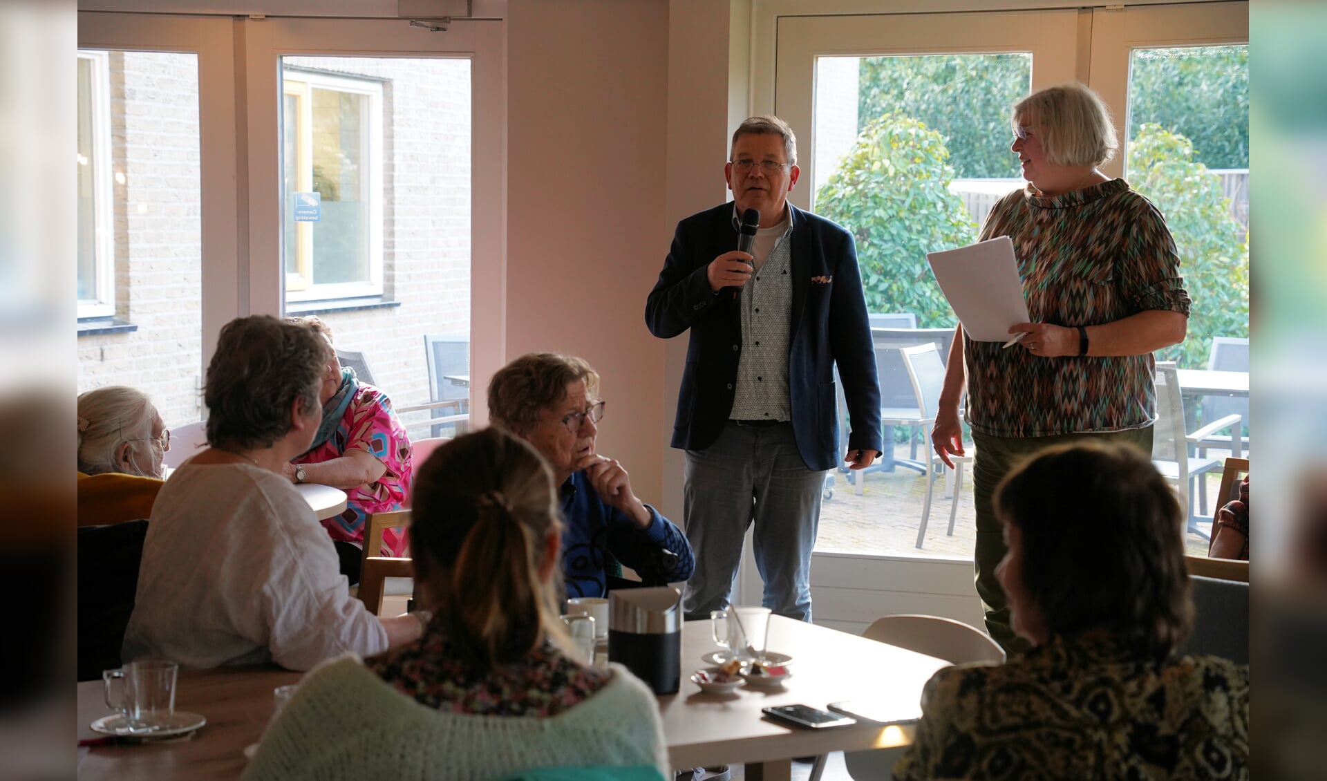 Wethouder Joop Wikkerink aan het woord, met naast hem Ria van Rooijen van het Vrouwencafé. Foto: Frank Vinkenvleugel
