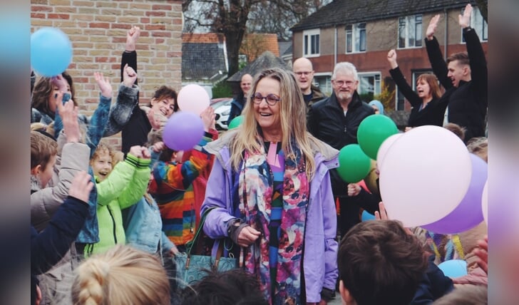 Corrie Elferink te midden van de kinderen. Achter haar staat haar man Jan. Foto: Henrike Grijsen