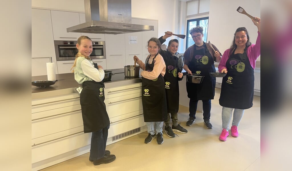 Met nieuwe schorten zijn Fem, Jennefer, Teun, Lizzy en Dieske helemaal klaar voor het kookproject. Foto: Karin van der Velden