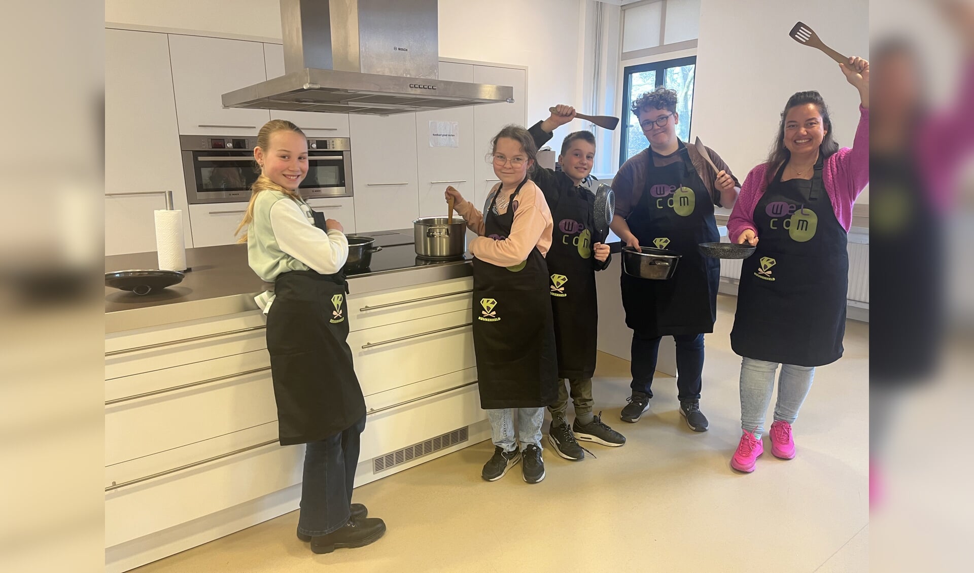 Met nieuwe schorten zijn Fem, Jennefer, Teun, Lizzy en Dieske helemaal klaar voor het kookproject. Foto: Karin van der Velden