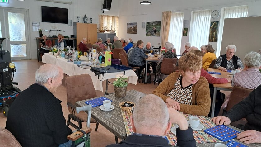 Gezonde spanning op de gezichten van de bingo-deelnemers rond de goed gevulde prijzentafel. Foto: Martina Derksen