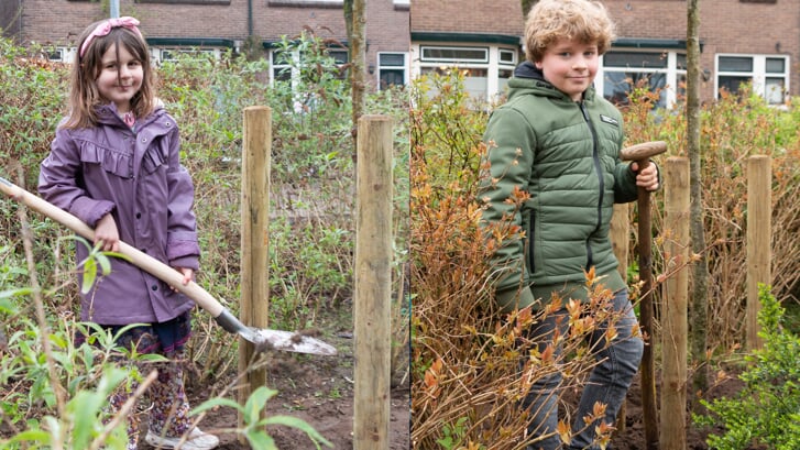 Twee van de kinderen die hebben geholpen de bomen vast in de grond te zetten. Foto: Henk Derksen