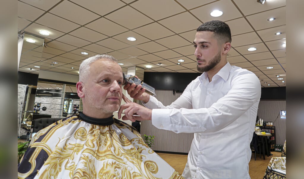 Dolouvan Haidar ontving bij de opening vrijdag direct zijn eerste klanten in zijn nieuwe barbershop in de Hengelose Raadhuisstraat. Foto: Luuk Stam