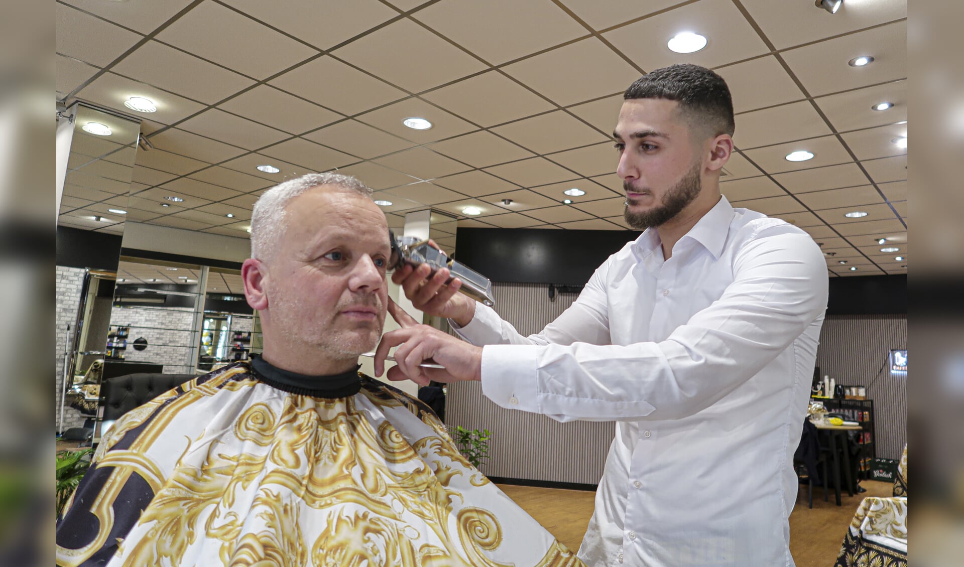 Dolouvan Haidar ontving bij de opening vrijdag direct zijn eerste klanten in zijn nieuwe barbershop in de Hengelose Raadhuisstraat. Foto: Luuk Stam