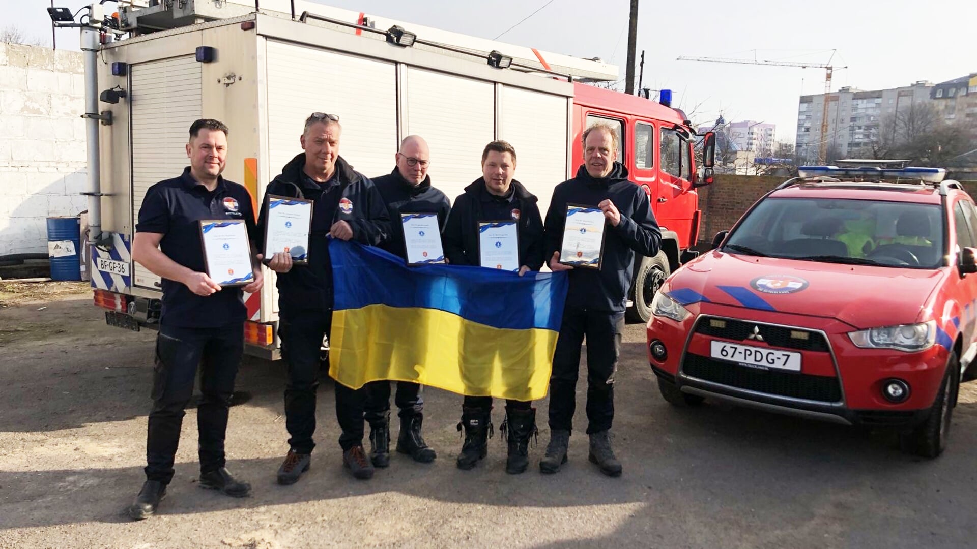 Albert Wichers (r) en Rick Bruggeman (tweede van rechts) ontvingen met hun collega's uit Borne en Enschede in Oekraïne een certificaat voor hun hulp. Foto: PR