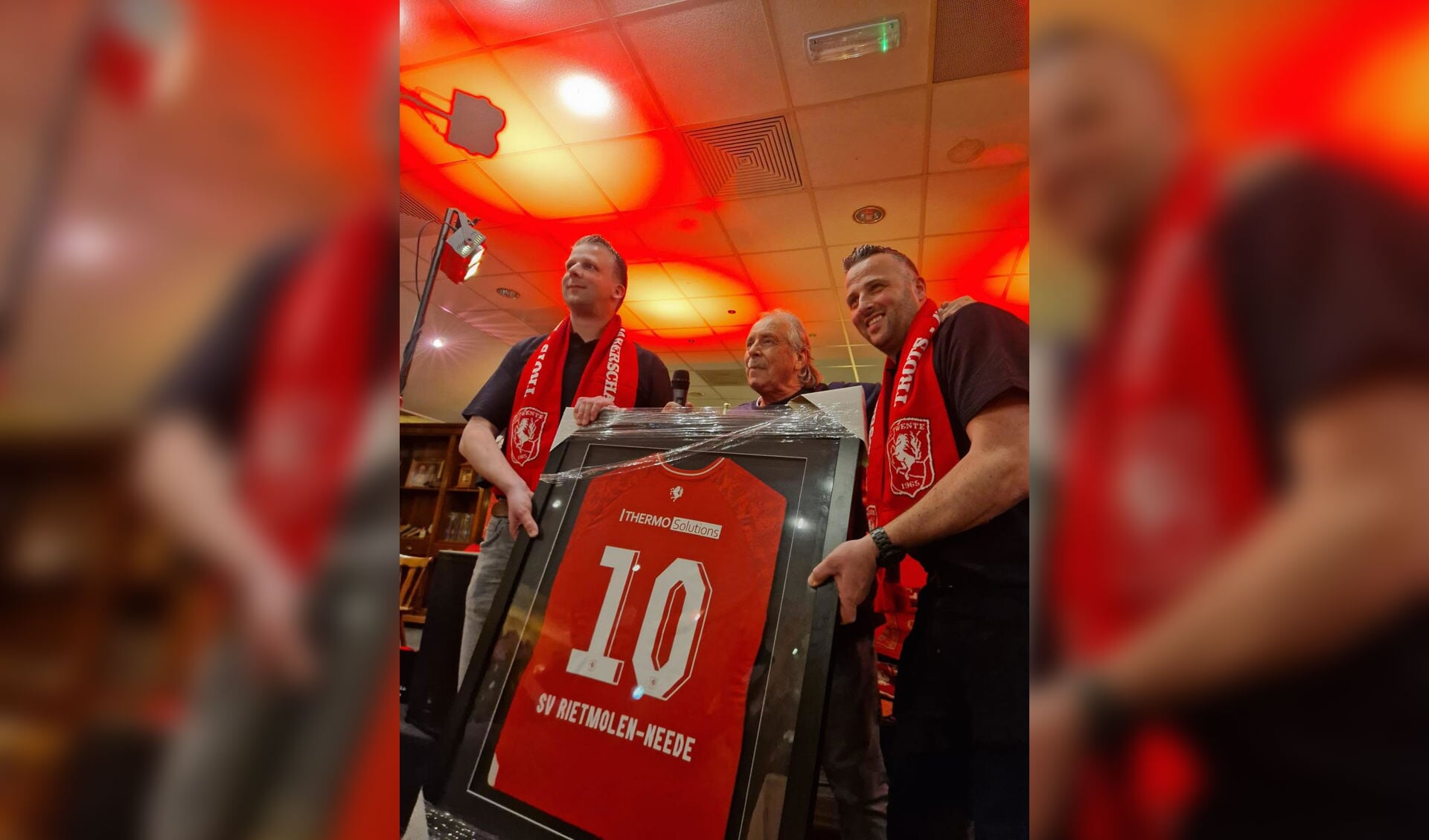 Voorzitters Rick Bolster (l) en Jordy Veldhuis met het speciale jubileumshirt van de supportersvereniging FC Twente Rietmolen/Neede. Foto: PR