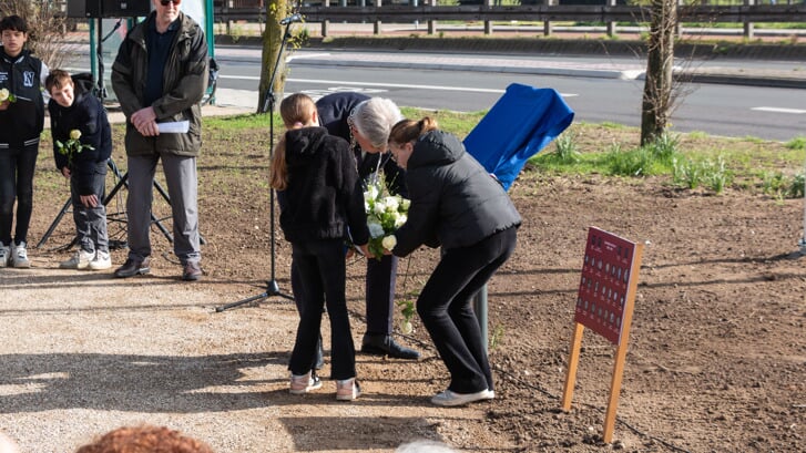 Gadegeslagen door hun medeleerlingen van de Jenaplanschool en door voorzitter Zwier ter Mul van herdenkingscomité De Hoven leggen Lorena en Amy samen met burgemeester Wimar Jaeger een krans bij het informatiebord dat even later wordt onthuld. Foto: Henk Derksen