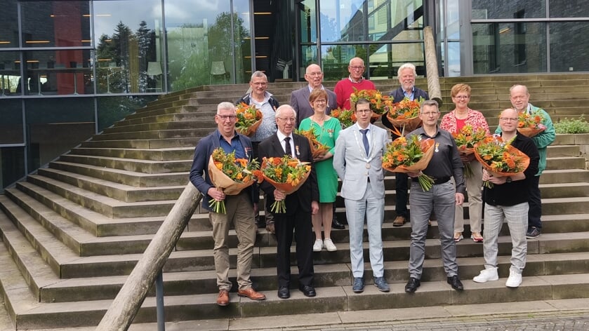 Elf van de twaalf gedecoreerde Berkellanders met burgemeester Joost van Oostrum (de heer Bennink ontving zijn onderscheiding in Oost Gelre). Foto: Rob Stevens