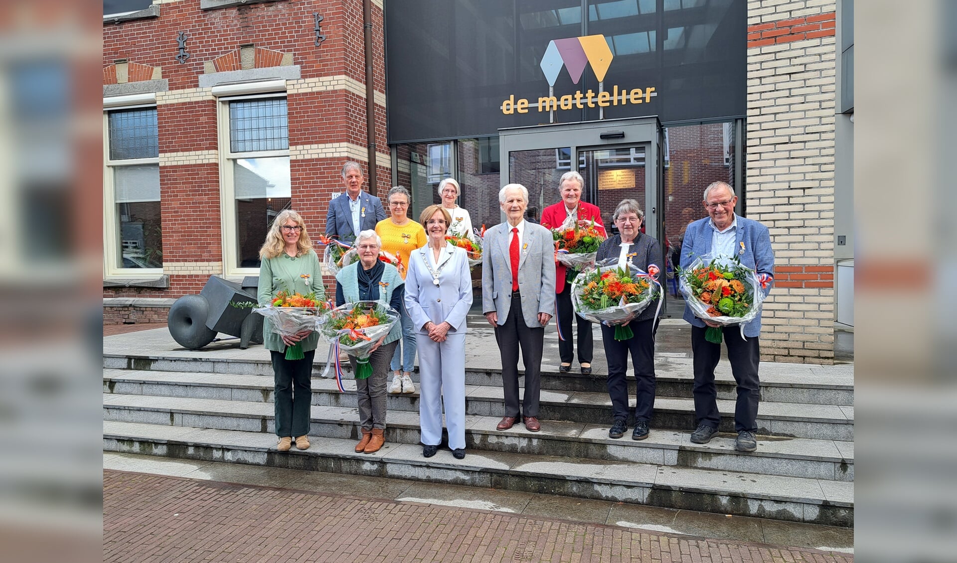 Henny Bennink (met rode stropdas) te midden van de andere gedecoreerden en partners en burgemeester Bronsvoort van Oost Gelre. Foto: Kyra Broshuis