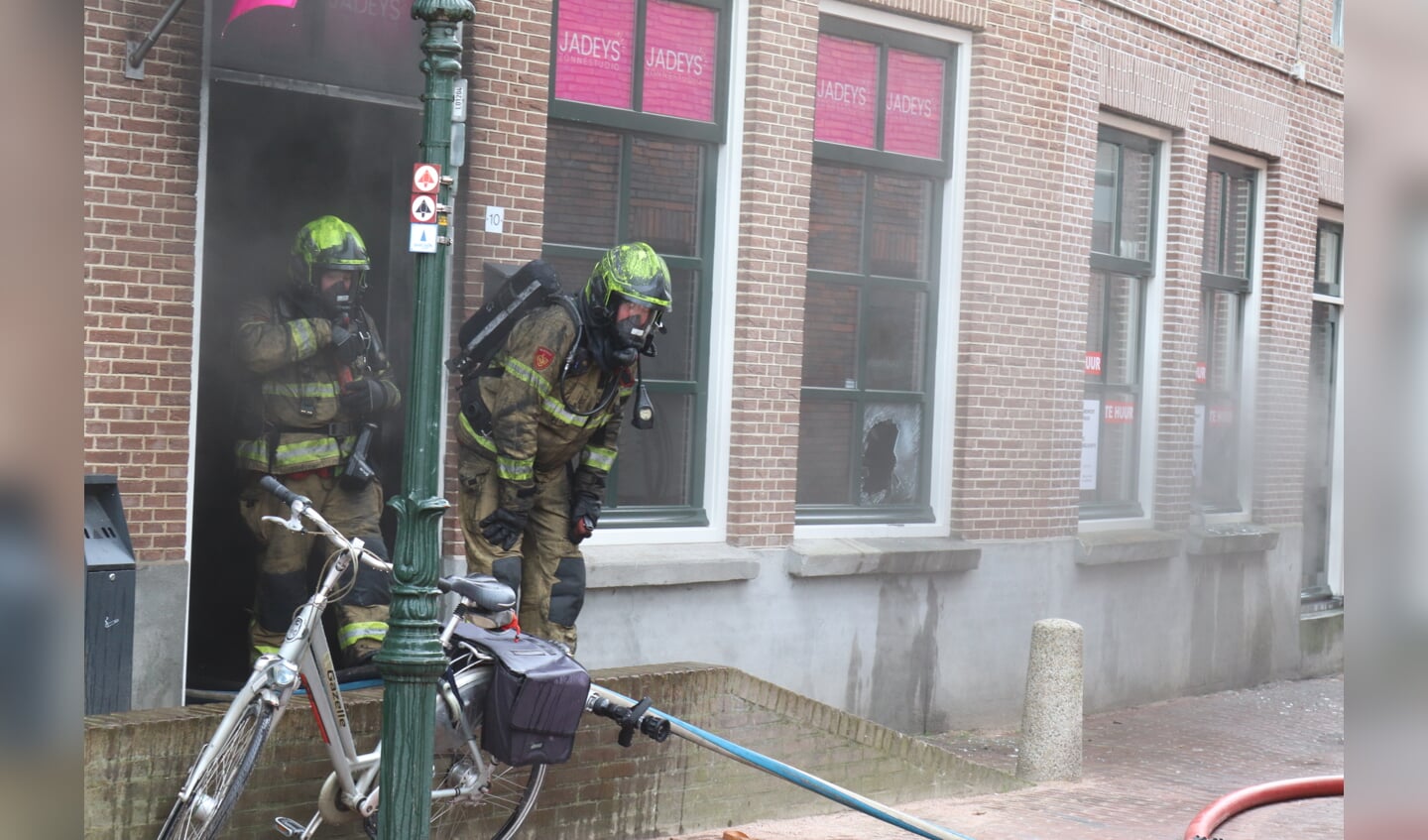 De brandweerlieden die met luchtdrukflessen de brand van binnenuit bestreden kwamen binnen tien minuten onder het roet naar buiten. Foto: Arjen Dieperink